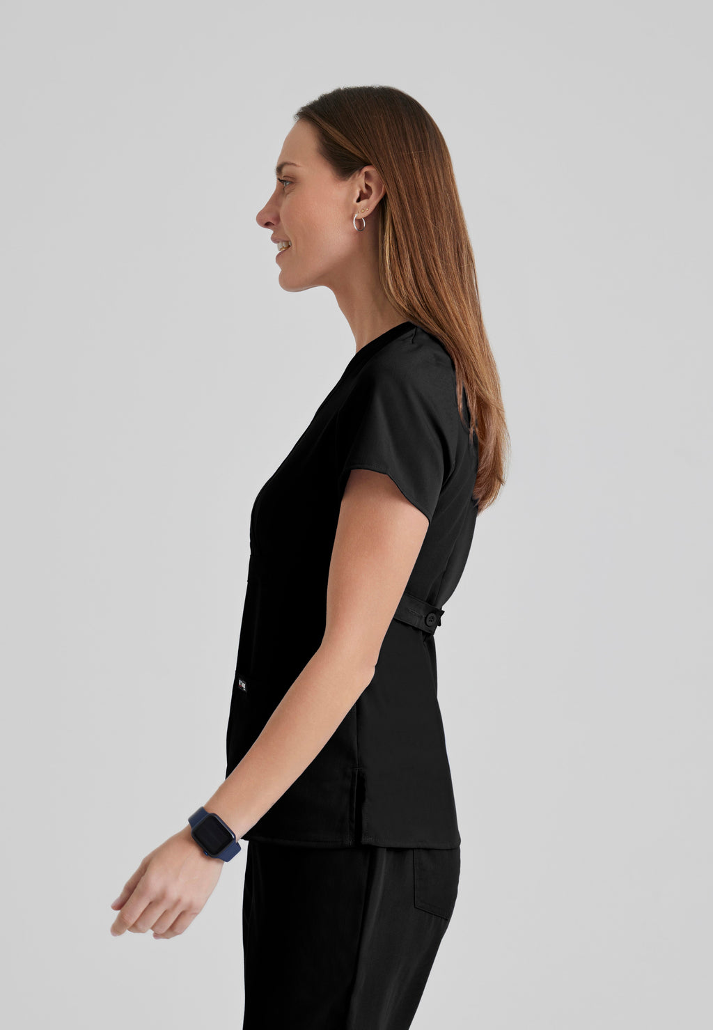 Side View of the Riley 3-Pocket Mock Wrap V-Neck Scrub Top in Black from Grey's Anatomy™ by Barco Classic