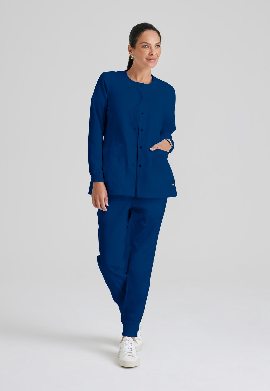 Full Body View of the Jamie 4-Pocket Crewneck Snap-Front Scrub Jacket in Indigo from Grey's Anatomy™ by Barco Classic