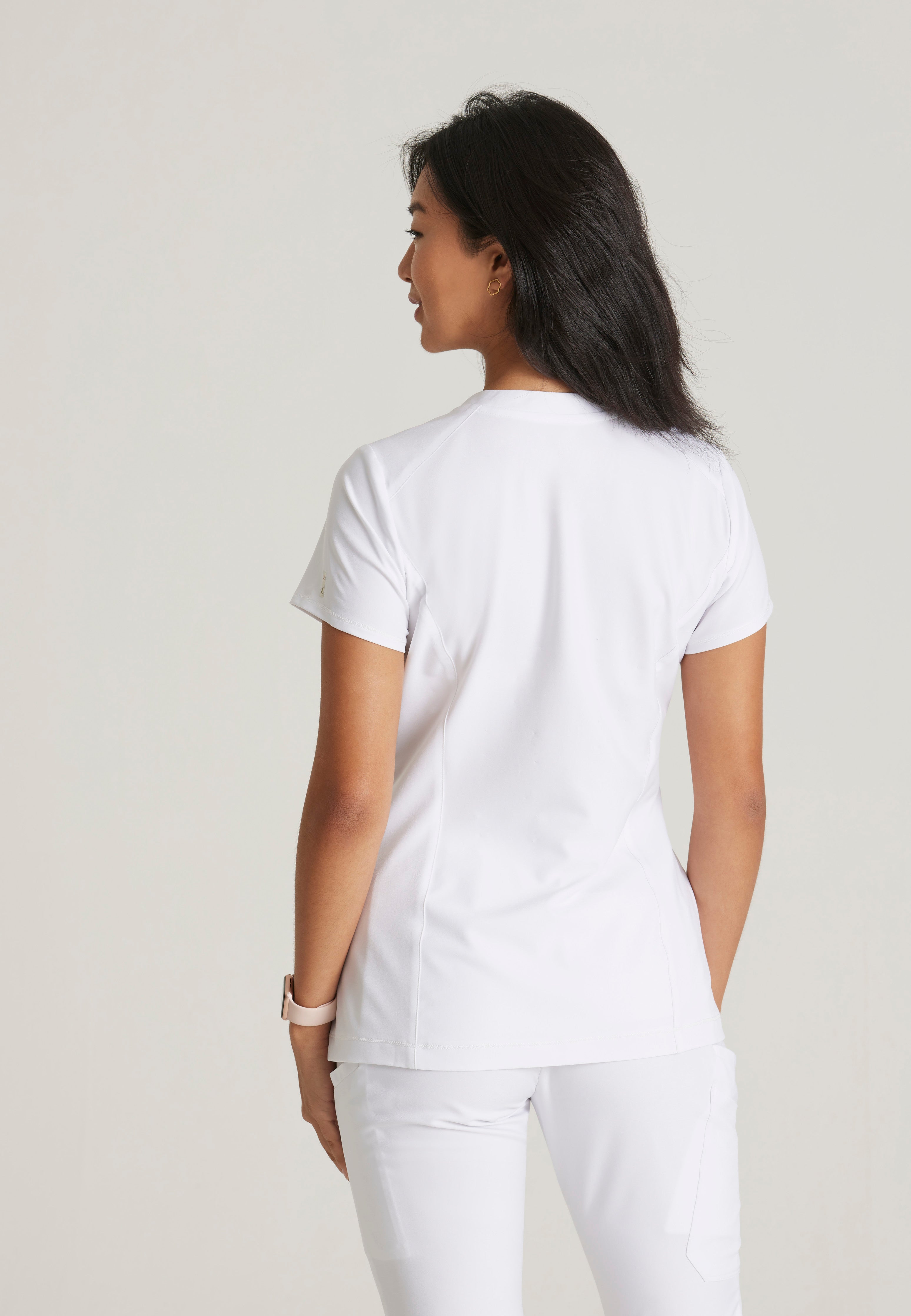 Back View of the Sway 1-Pocket Banded V-Neck Ciclo® Scrub Top in White from Grey's Anatomy™ by Barco Evolve