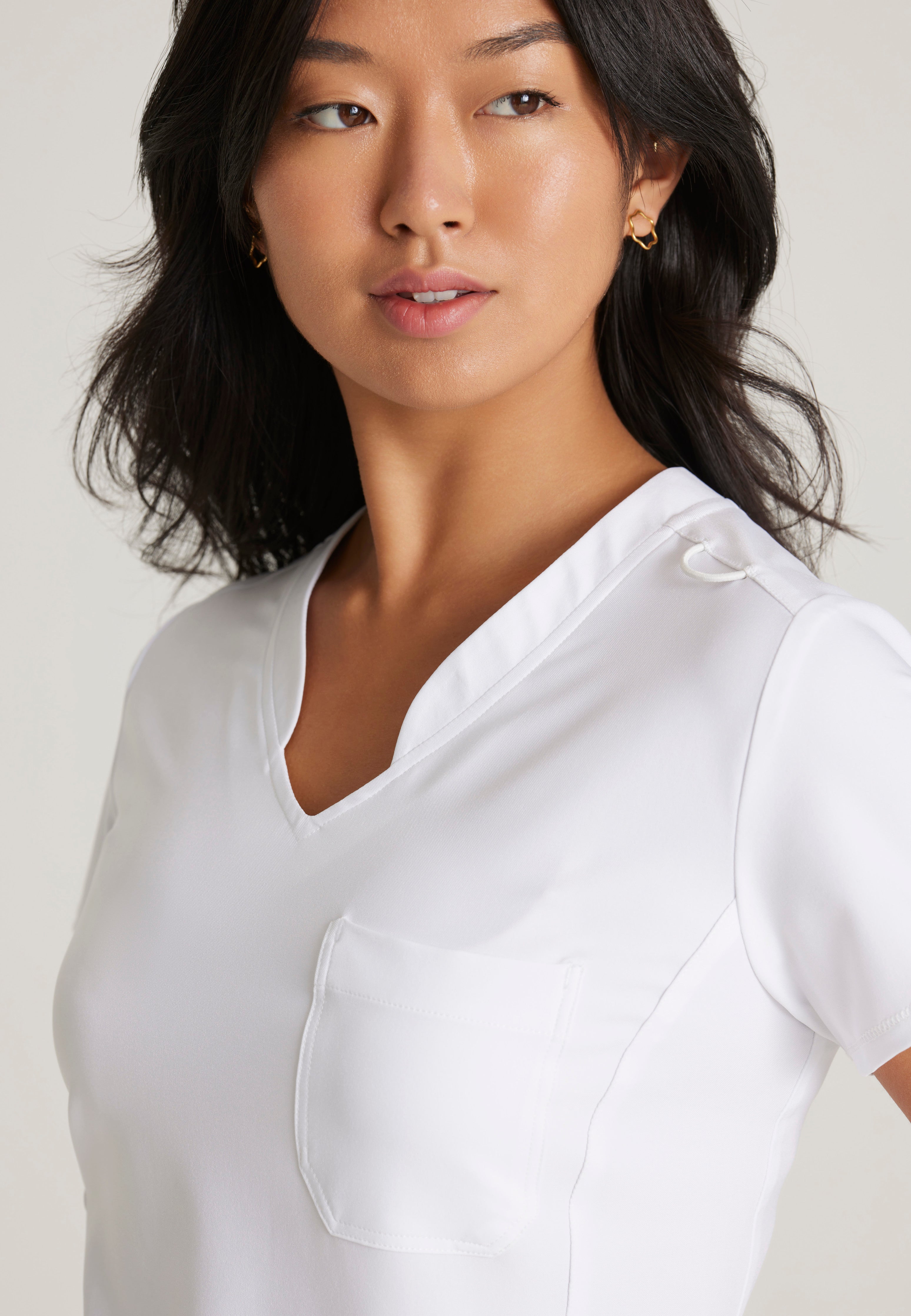 Detail Shot of the Sway 1-Pocket Banded V-Neck Ciclo® Scrub Top in White from Grey's Anatomy™ by Barco Evolve