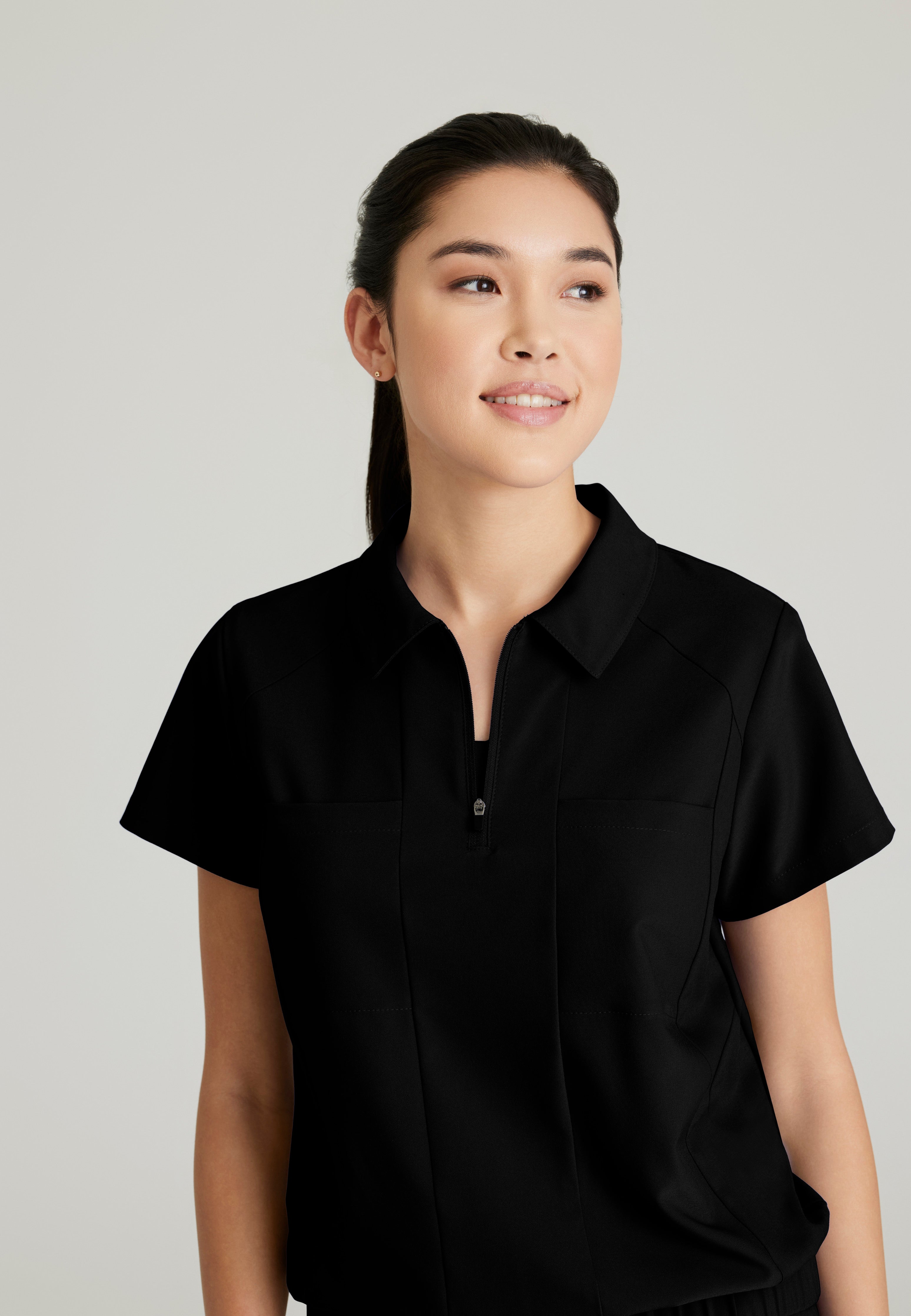 Detail Shot of the Perseverance 2-Pocket Zip Neck Banded Waist Top in Black from Grey's Anatomy™ by Barco Evolve