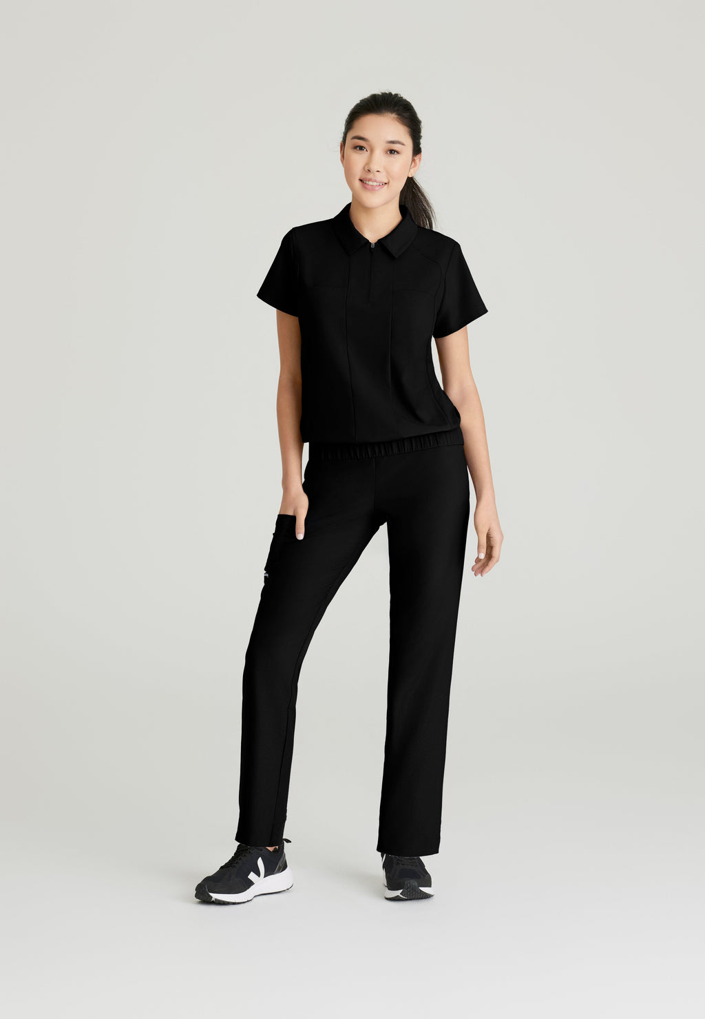 Full Body View of the Perseverance 2-Pocket Zip Neck Banded Waist Top in Black from Grey's Anatomy™ by Barco Evolve