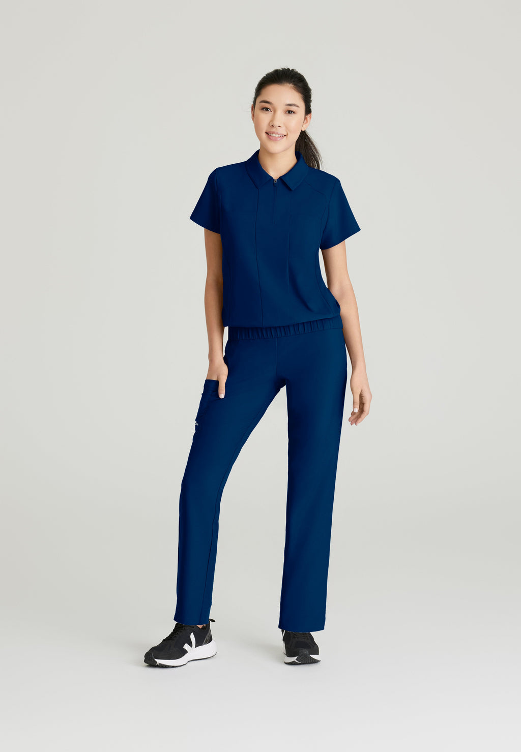 Full Body View of the Perseverance 2-Pocket Zip Neck Banded Waist Top in Indigo from Grey's Anatomy™ by Barco Evolve