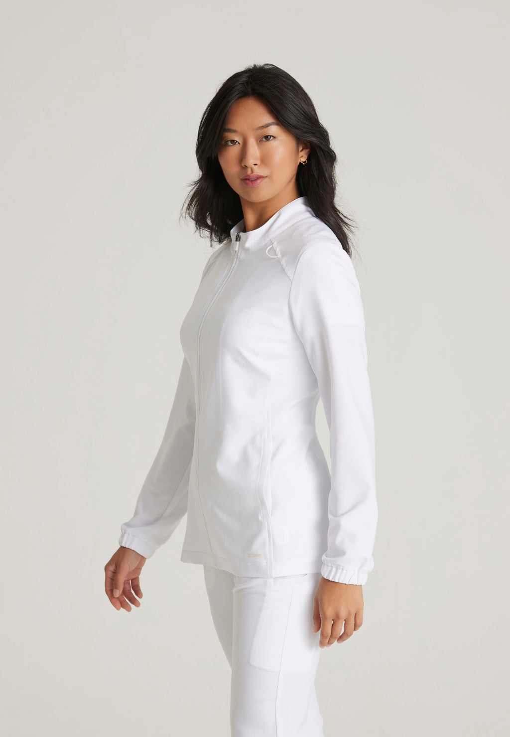 Side View of the Virtue 3-Pocket Stand-Up Collar Ciclo® Scrub Jacket in White from Grey's Anatomy™ by Barco Evolve