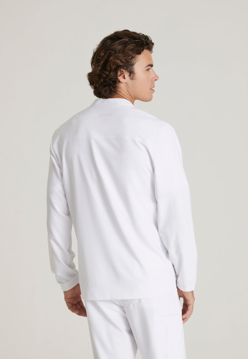 Back View of the Cycle 3-Pocket Crewneck Ciclo® Scrub Jacket in White from Grey's Anatomy™ by Barco Evolve
