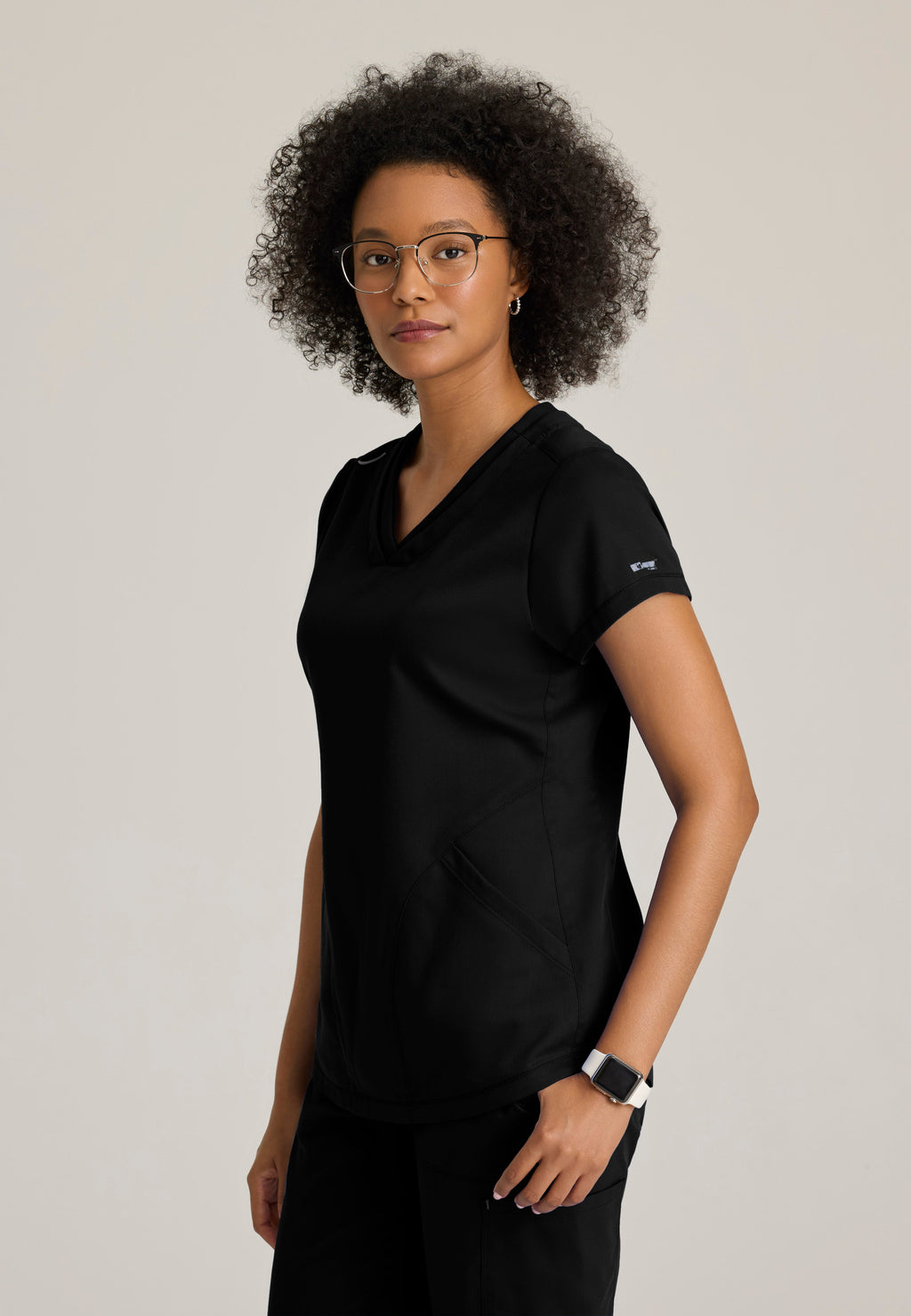 Side View of the Evelyn Pintuck Detail Scrub Top in Black from Grey's Anatomy™ by Barco Classic