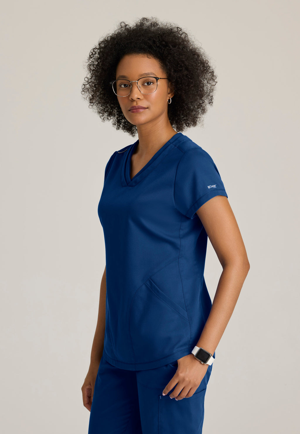 Side View of the Evelyn Pintuck Detail Scrub Top in Indigo from Grey's Anatomy™ by Barco Classic