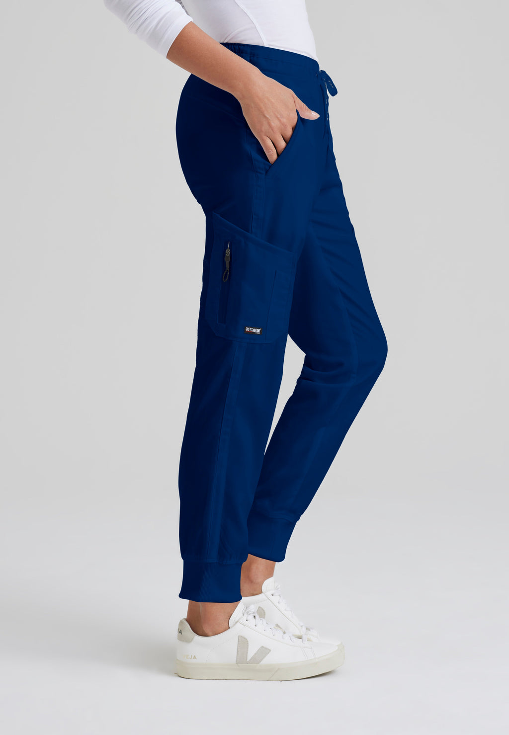 Side View of the Kira 5-Pocket Mid-Rise Jogger Scrub Pant in Indigo from Grey's Anatomy™ by Barco Classic