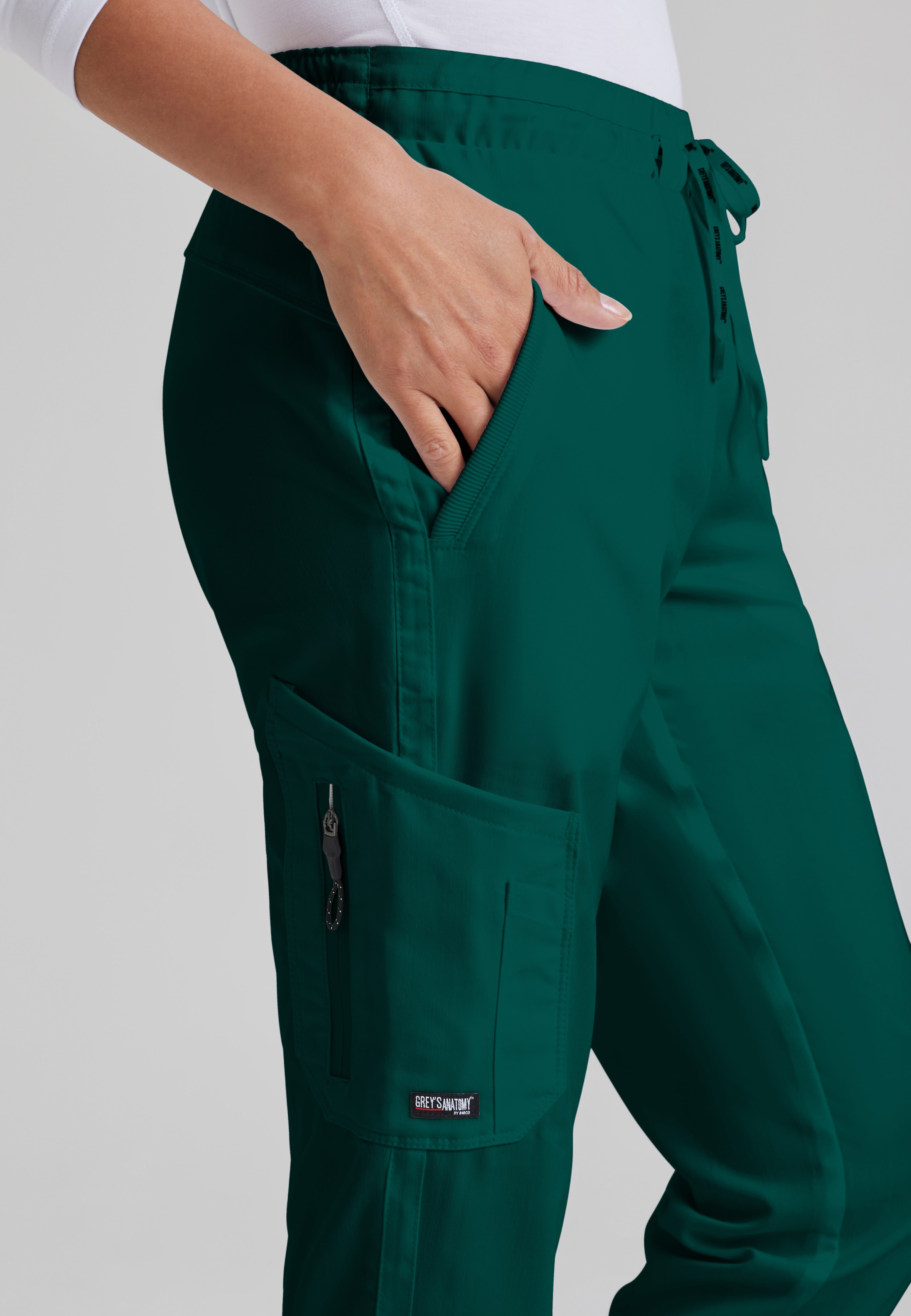 Detail Shot of the Kira 5-Pocket Mid-Rise Jogger Scrub Pant in Hunter Green from Grey's Anatomy™ by Barco Classic