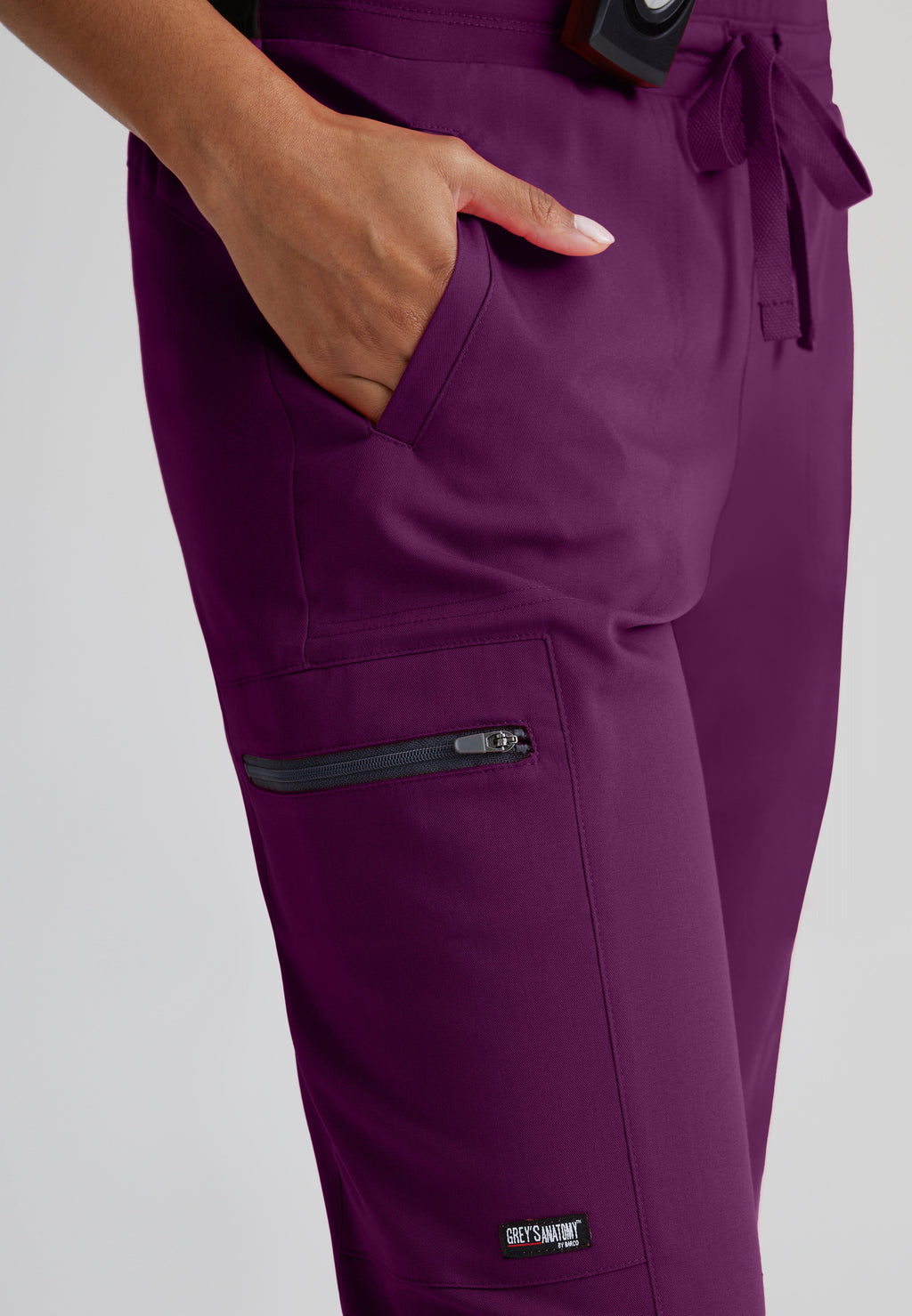 Detail Shot of the Kim 3-Pocket Mid-Rise Straight Leg Scrub Pant in Wine from Grey's Anatomy™ by Barco Spandex Stretch