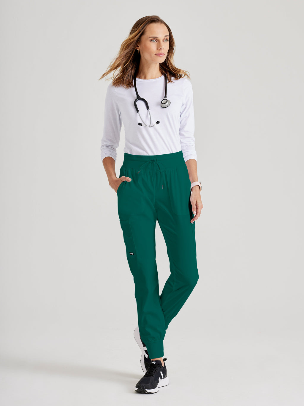 Full Body View of the Carly 7-Pocket Mid-Rise Jogger Scrub Pant in Hunter Green from Grey's Anatomy™ by Barco Spandex Stretch