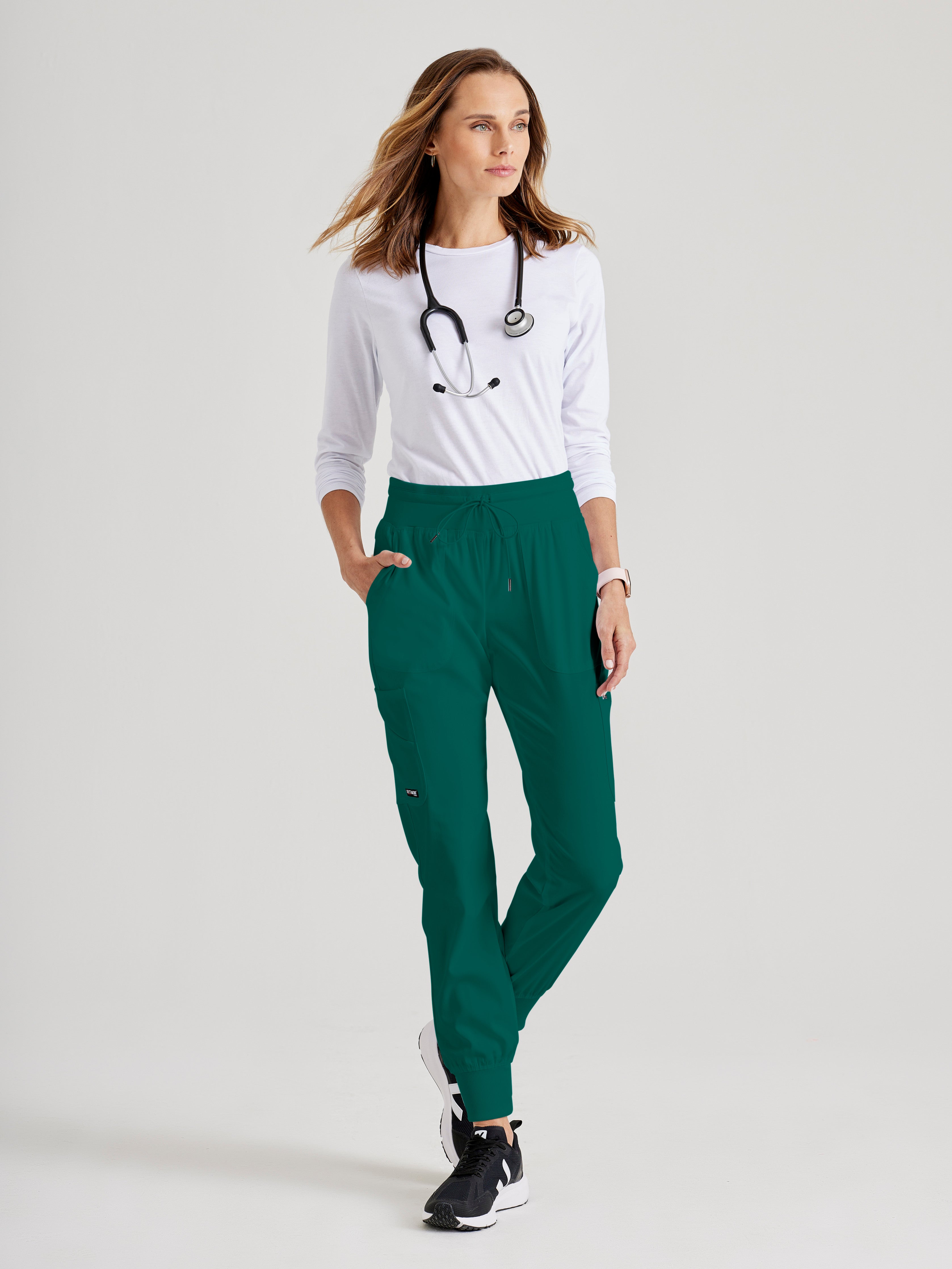 Full Body View of the Carly 7-Pocket Mid-Rise Jogger Scrub Pant in Hunter Green from Grey's Anatomy™ by Barco Spandex Stretch