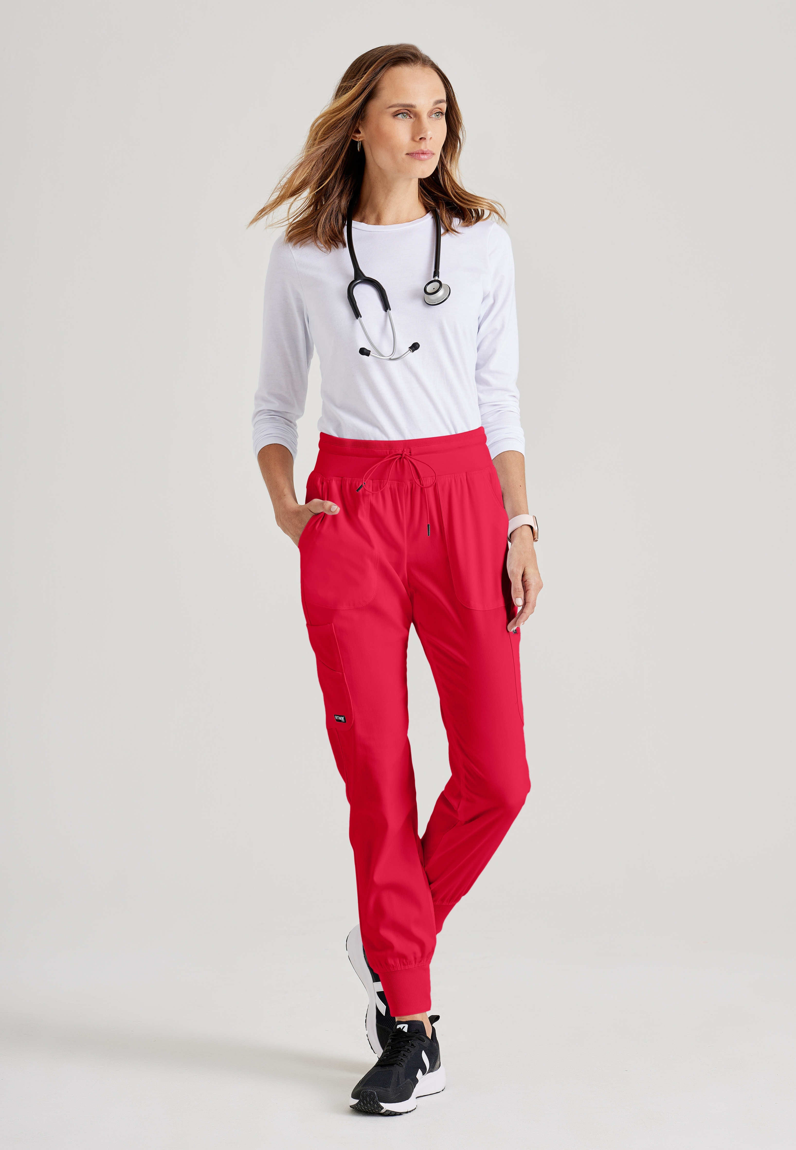 Full Body View of the Carly 7-Pocket Mid-Rise Jogger Scrub Pant in Scarlet Red from Grey's Anatomy™ by Barco Spandex Stretch