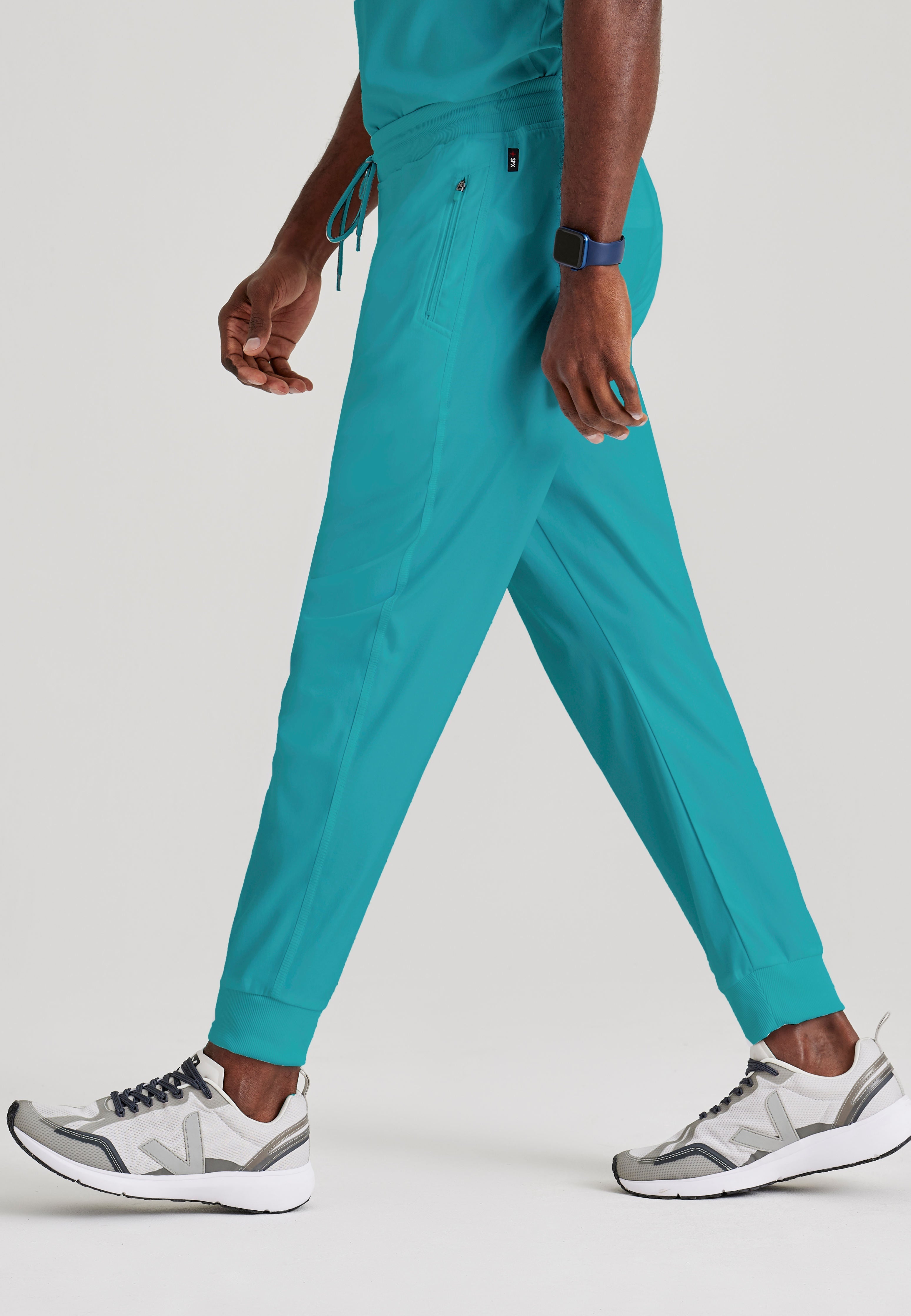 Grey's Anatomy Spandex-Stretch Men’s teal Zip-Fly 5-Pocket Jogger Scrub Pant. Elastic waistband with drawstring. Wrinkle-resistant, easy care fabric. 