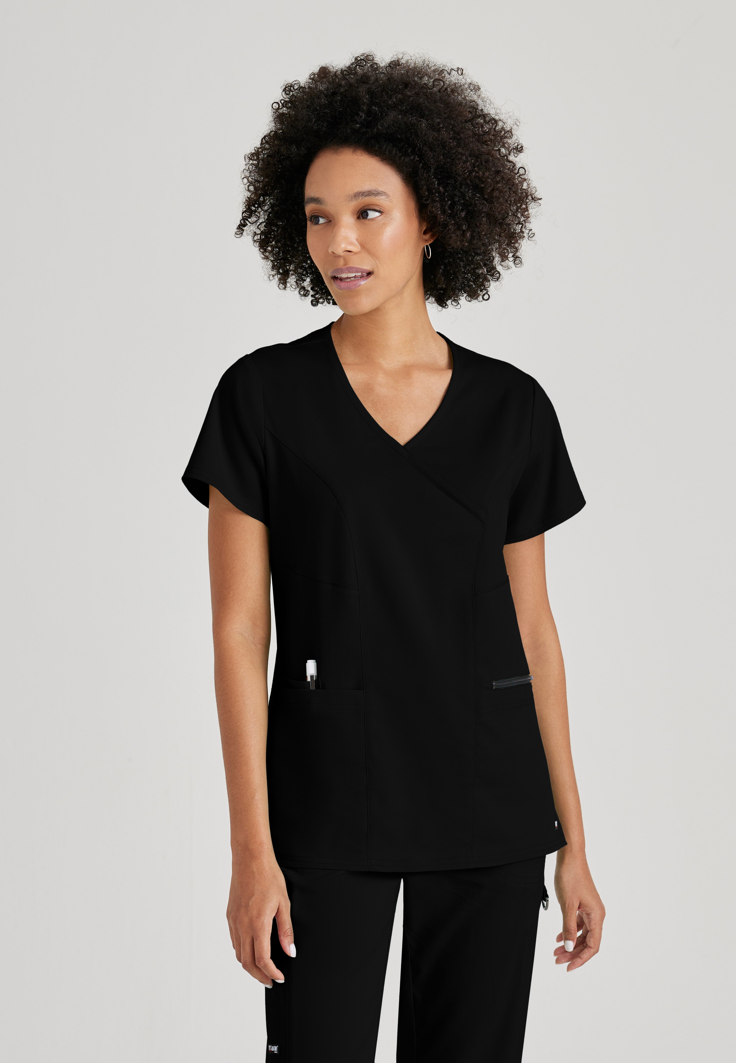 Front View of the Kim 3-Pocket Crossover V-Neck Scrub Top in Black from Grey's Anatomy™ by Barco Spandex Stretch