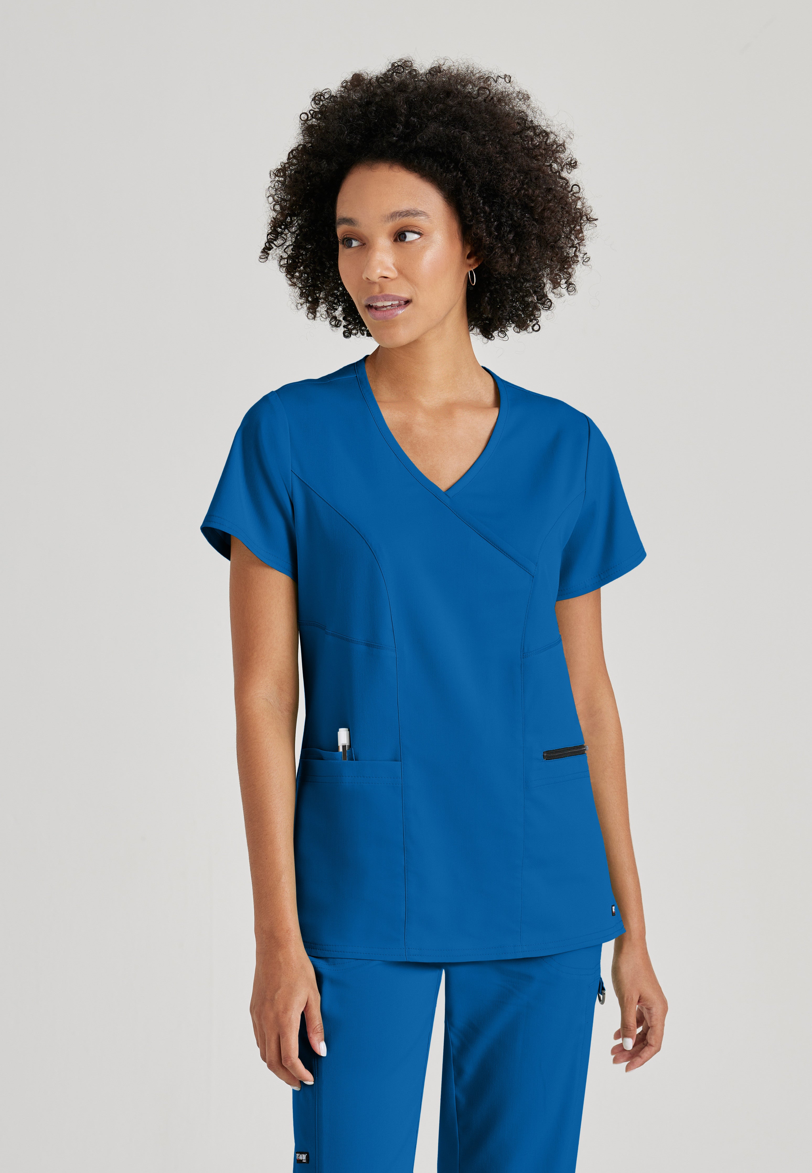 Front View of the Kim 3-Pocket Crossover V-Neck Scrub Top in New Royal from Grey's Anatomy™ by Barco Spandex Stretch