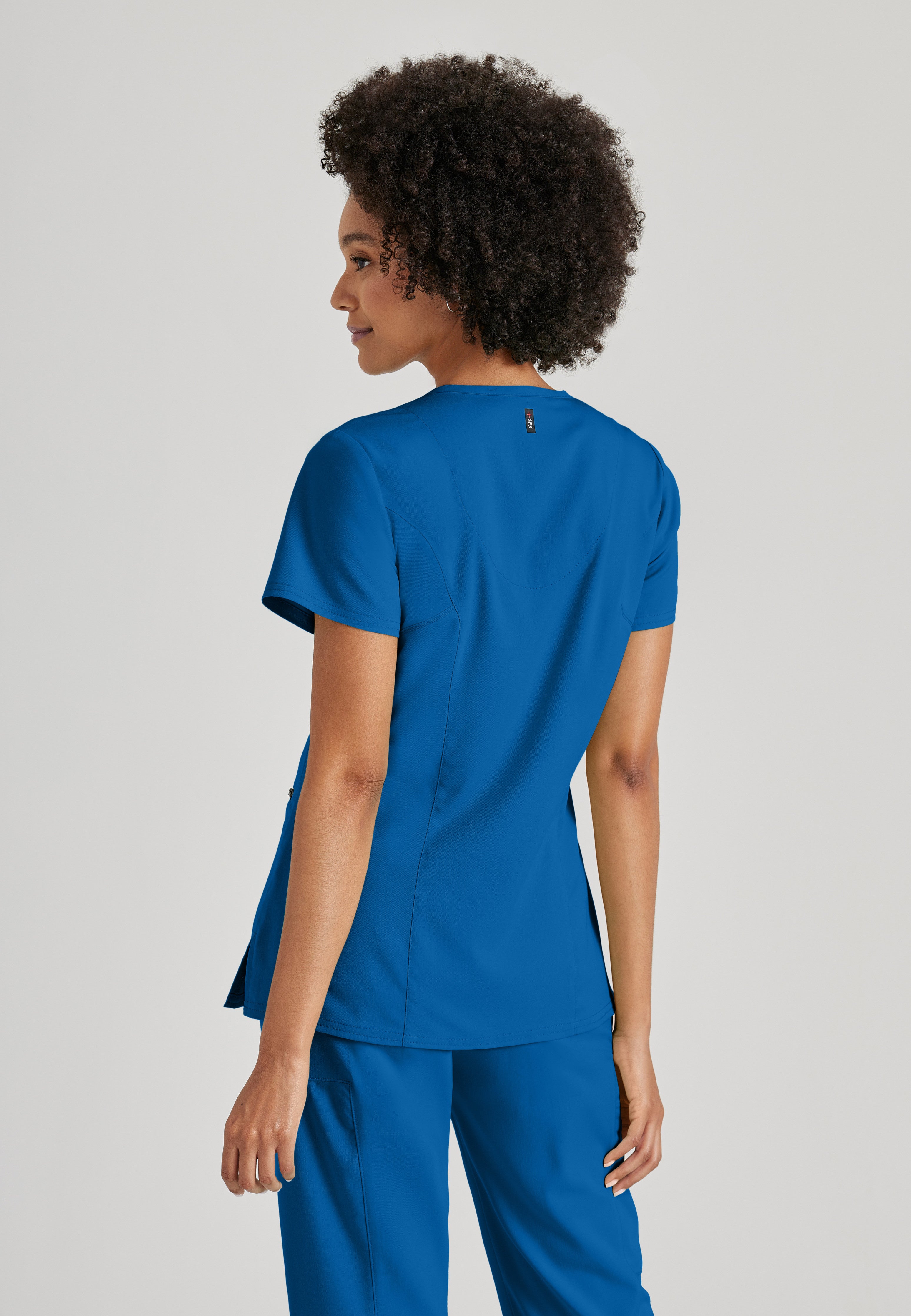 Side View of the Kim 3-Pocket Crossover V-Neck Scrub Top in New Royal from Grey's Anatomy™ by Barco Spandex Stretch