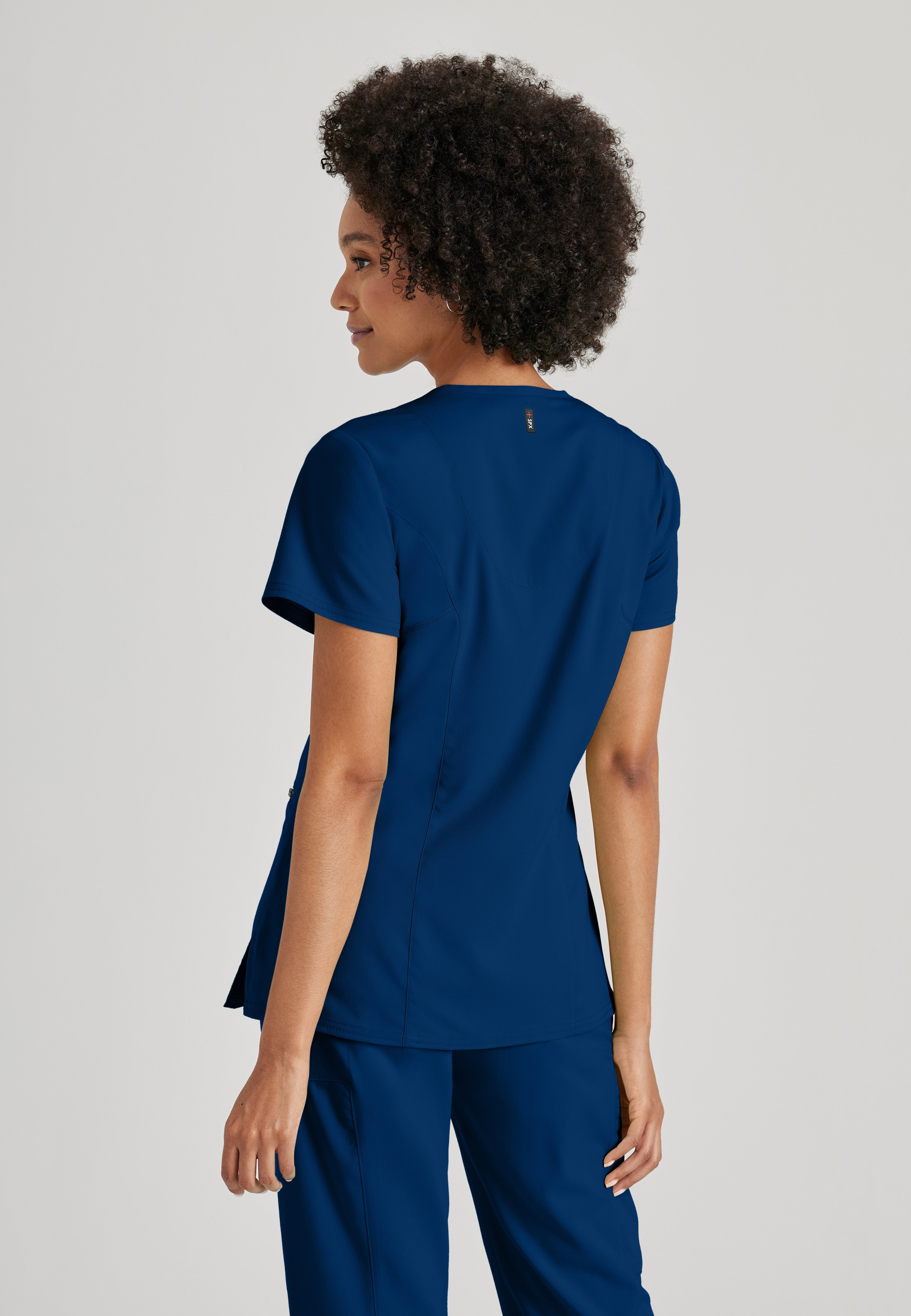 Side View of the Kim 3-Pocket Crossover V-Neck Scrub Top in Indigo from Grey's Anatomy™ by Barco Spandex Stretch
