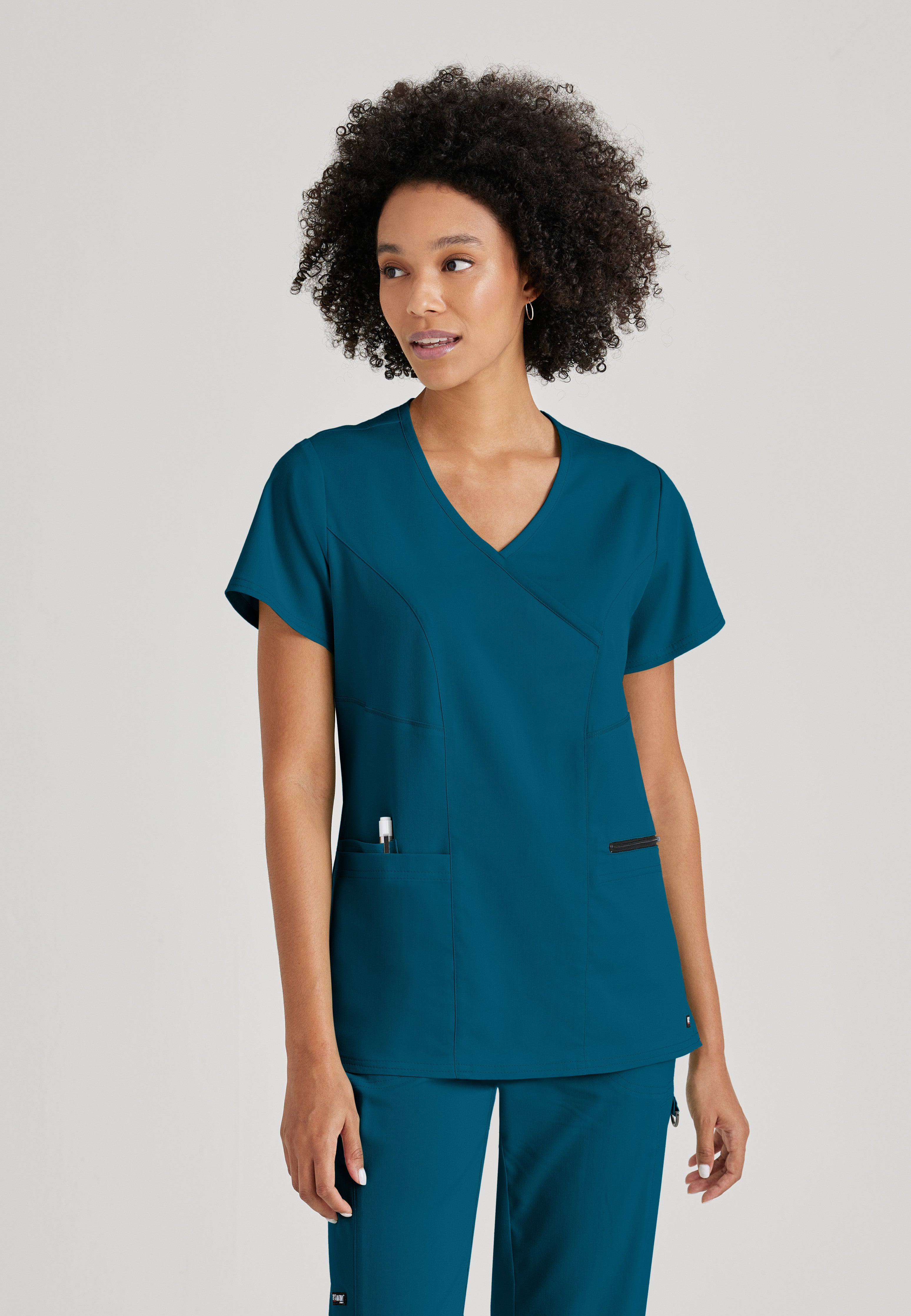Front View of the Kim 3-Pocket Crossover V-Neck Scrub Top in Bahama from Grey's Anatomy™ by Barco Spandex Stretch