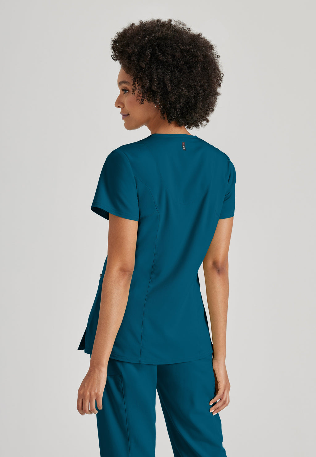 Side View of the Kim 3-Pocket Crossover V-Neck Scrub Top in Bahama from Grey's Anatomy™ by Barco Spandex Stretch