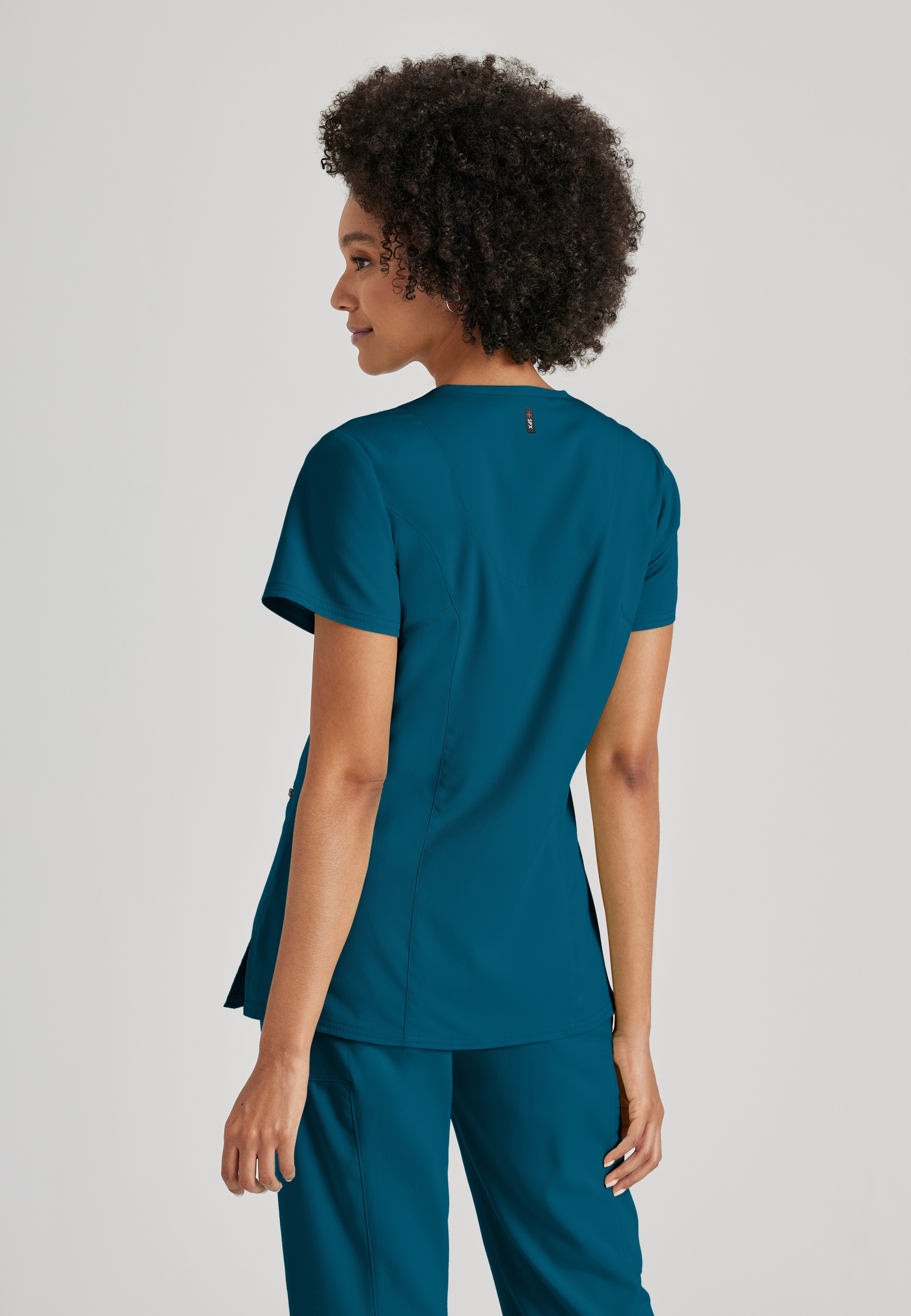 Side View of the Kim 3-Pocket Crossover V-Neck Scrub Top in Bahama from Grey's Anatomy™ by Barco Spandex Stretch