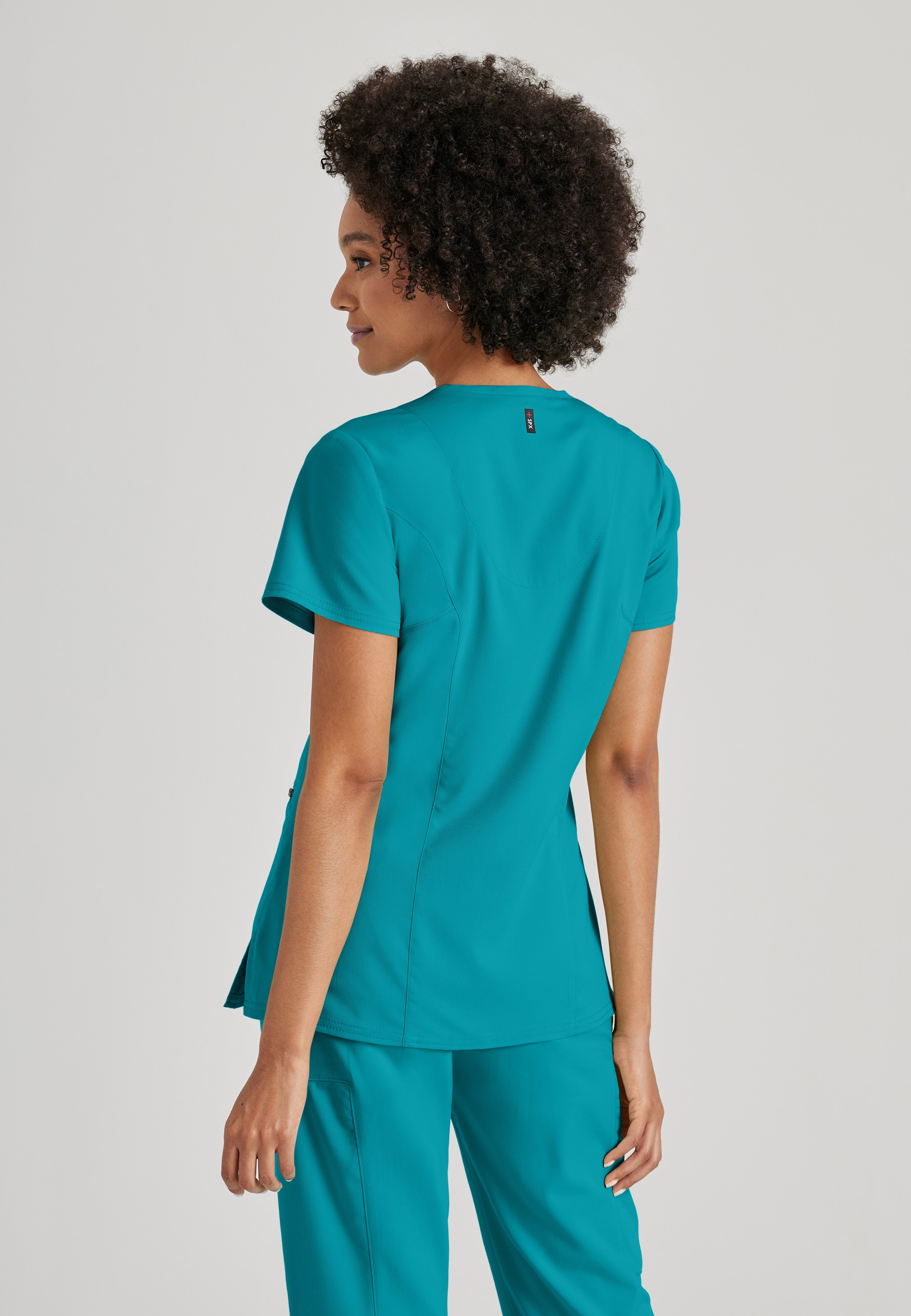 Side View of the Kim 3-Pocket Crossover V-Neck Scrub Top in Teal from Grey's Anatomy™ by Barco Spandex Stretch