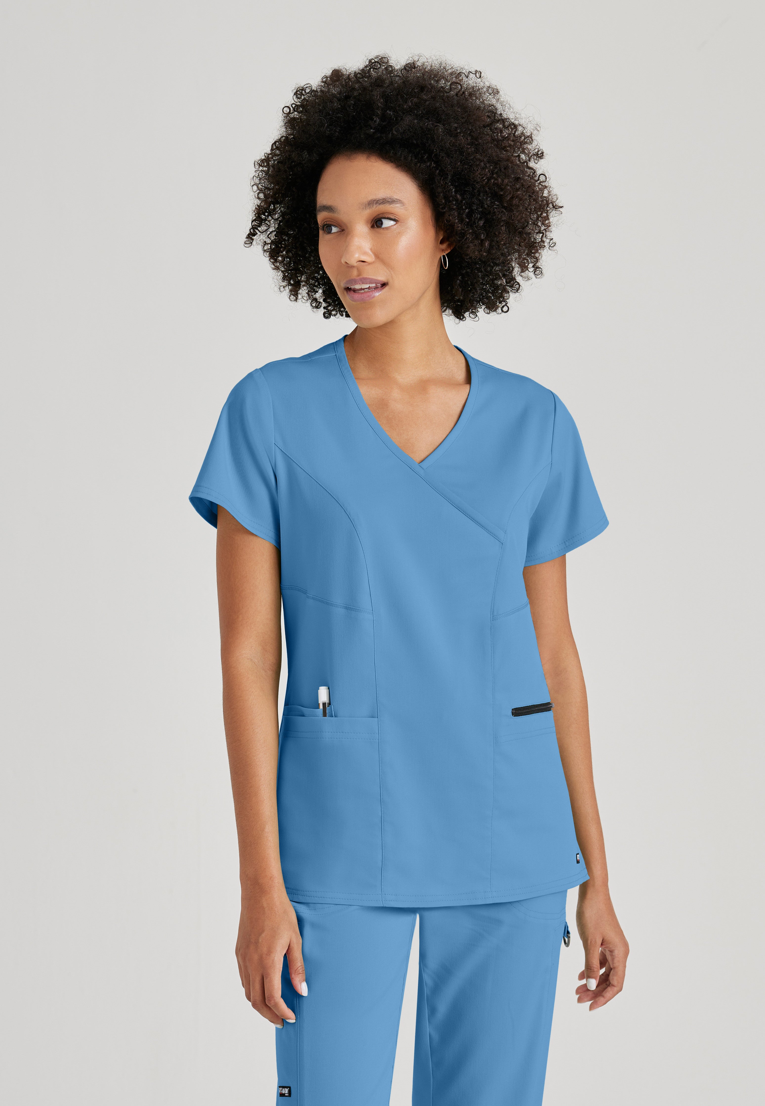 Front View of the Kim 3-Pocket Crossover V-Neck Scrub Top in Ciel Blue from Grey's Anatomy™ by Barco Spandex Stretch