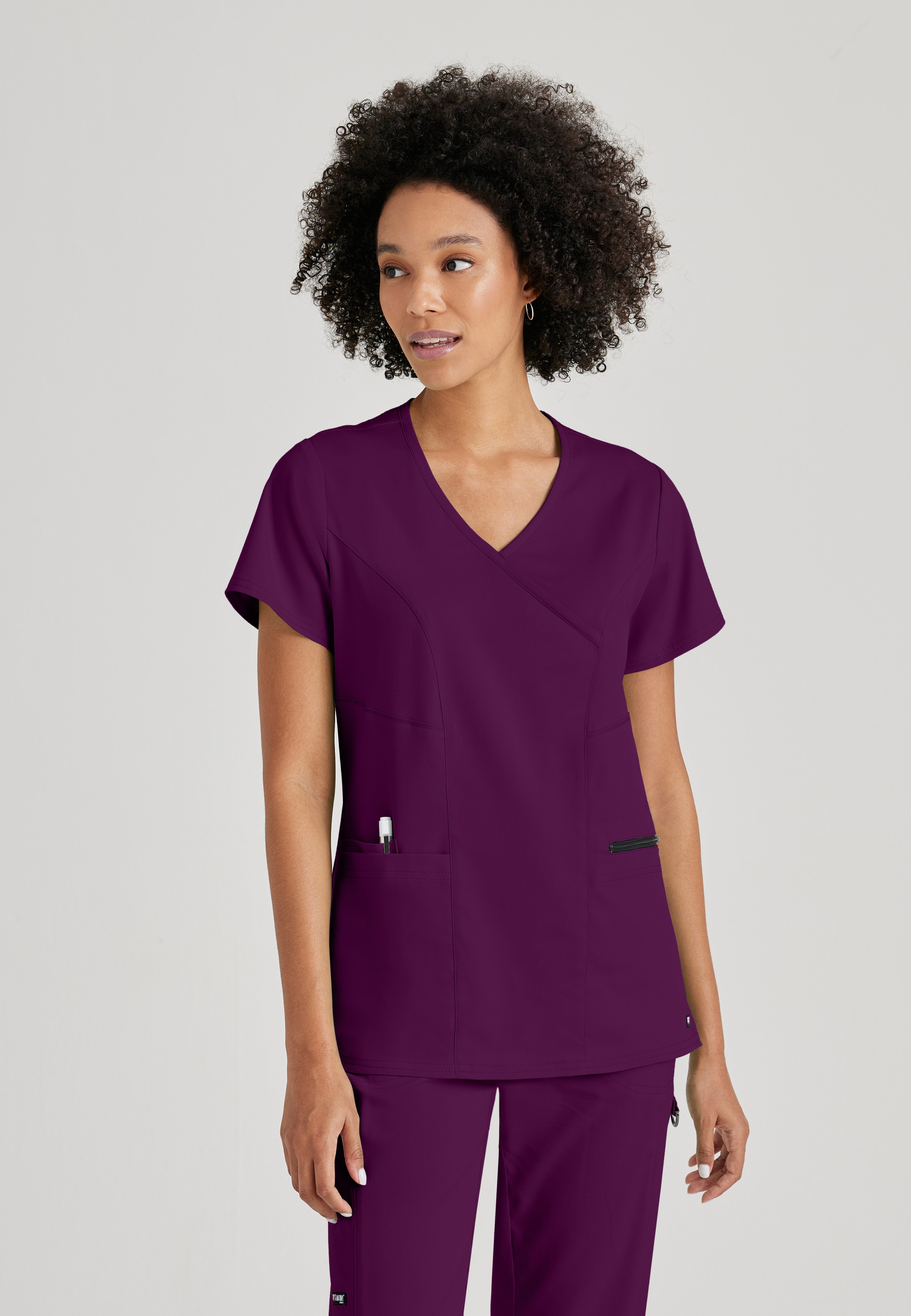 Front View of the Kim 3-Pocket Crossover V-Neck Scrub Top in Wine from Grey's Anatomy™ by Barco Spandex Stretch