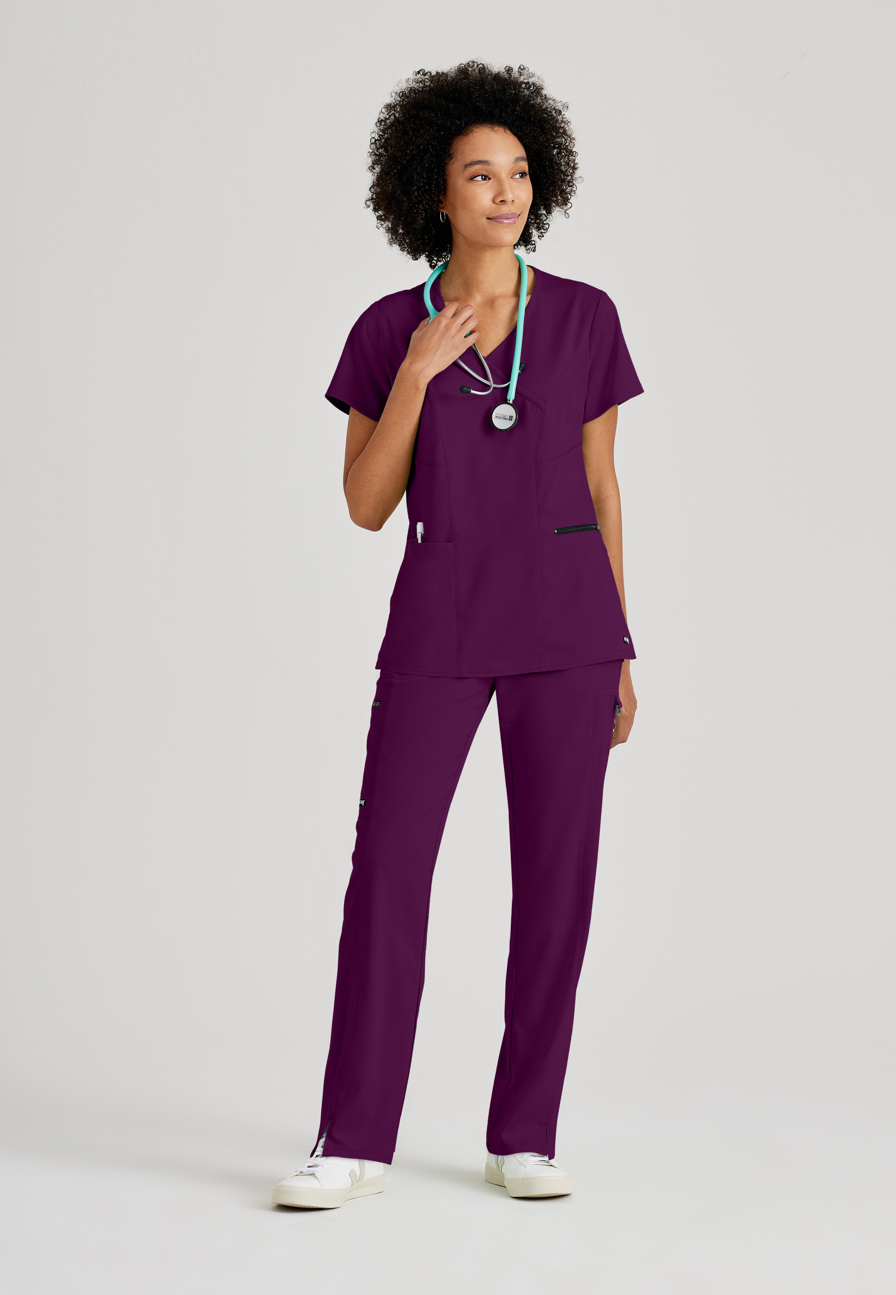 Full Body View of the Kim 3-Pocket Crossover V-Neck Scrub Top in Wine from Grey's Anatomy™ by Barco Spandex Stretch