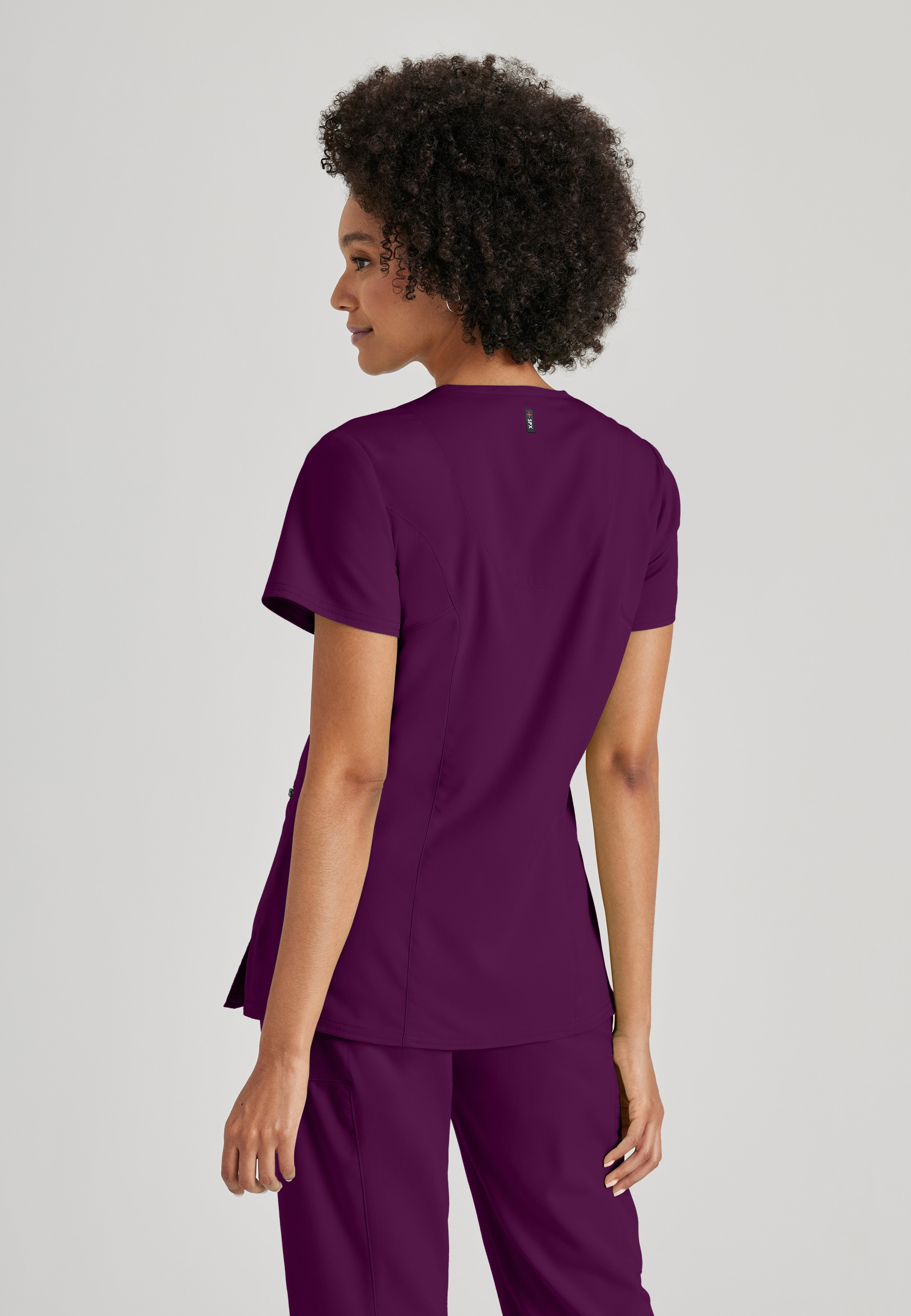 Side View of the Kim 3-Pocket Crossover V-Neck Scrub Top in Wine from Grey's Anatomy™ by Barco Spandex Stretch