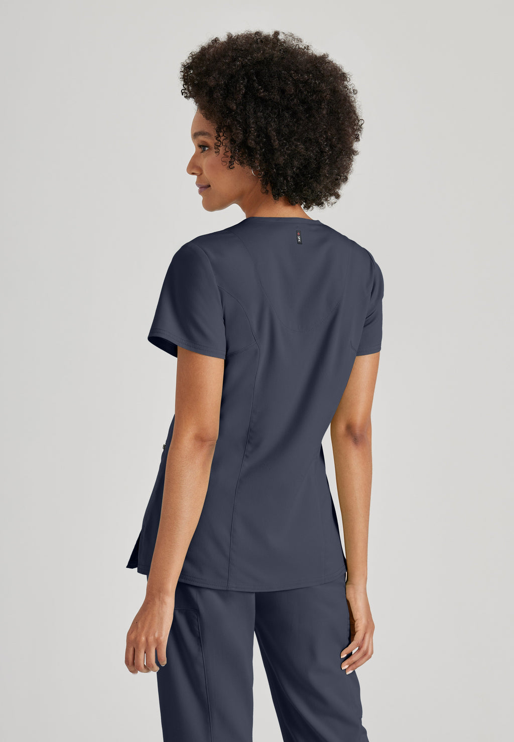 Side View of the Kim 3-Pocket Crossover V-Neck Scrub Top in Steel from Grey's Anatomy™ by Barco Spandex Stretch
