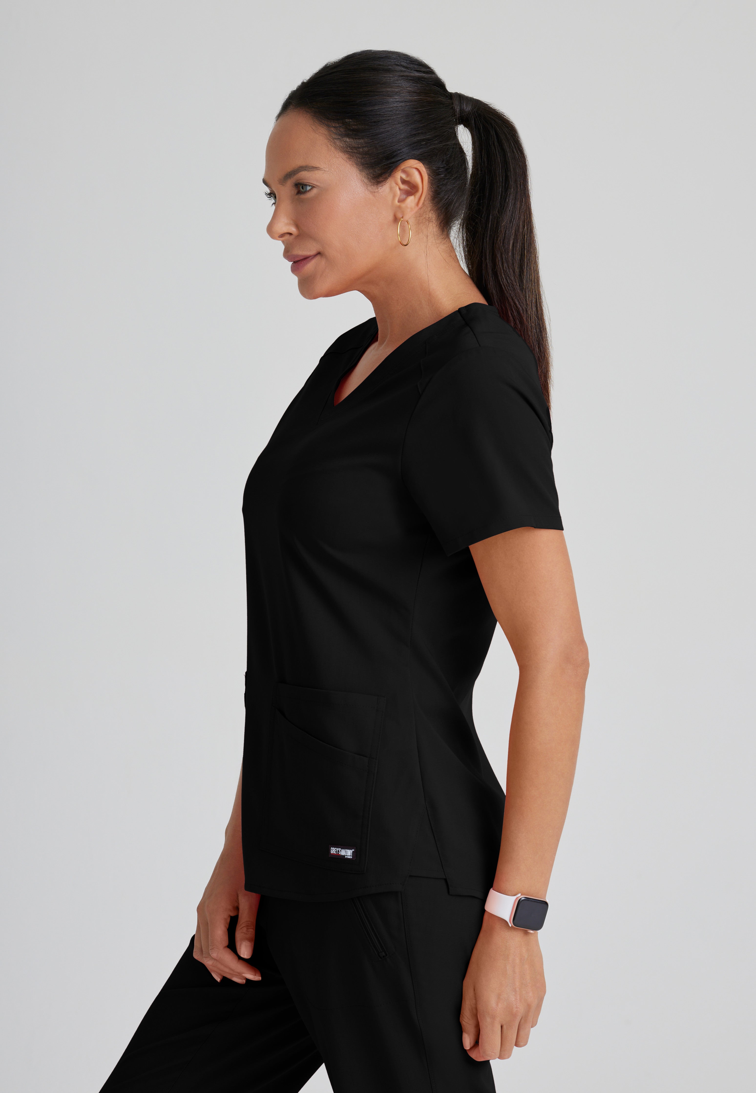 Side View of the Emma 4-Pocket V-Neck Scrub Top in Black from Grey's Anatomy™ by Barco Spandex Stretch