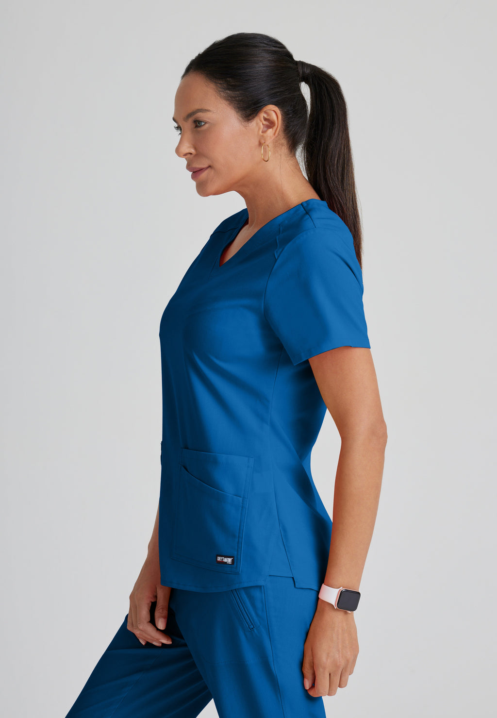 Side View of the Emma 4-Pocket V-Neck Scrub Top in New Royal from Grey's Anatomy™ by Barco Spandex Stretch