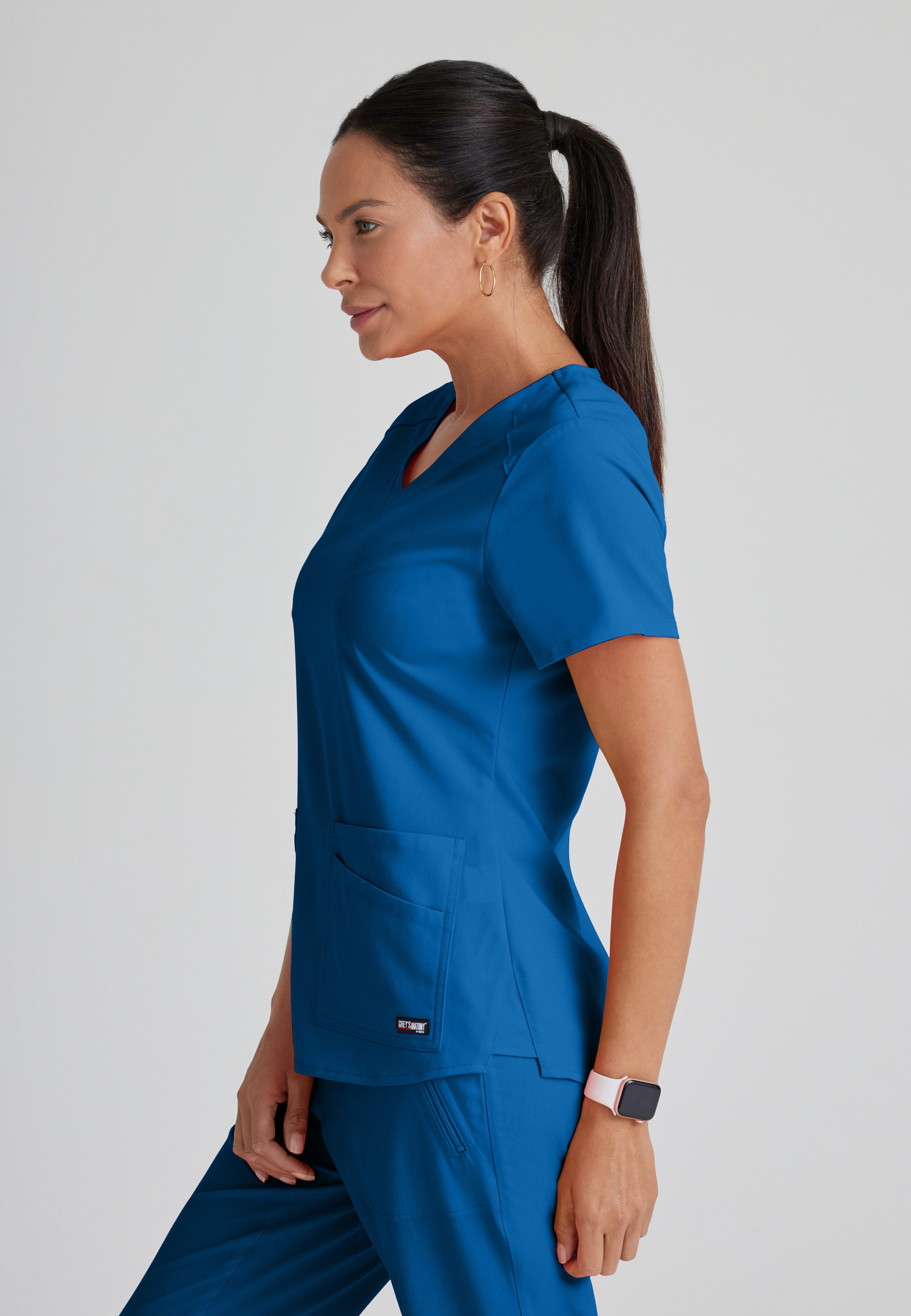 Side View of the Emma 4-Pocket V-Neck Scrub Top in New Royal from Grey's Anatomy™ by Barco Spandex Stretch