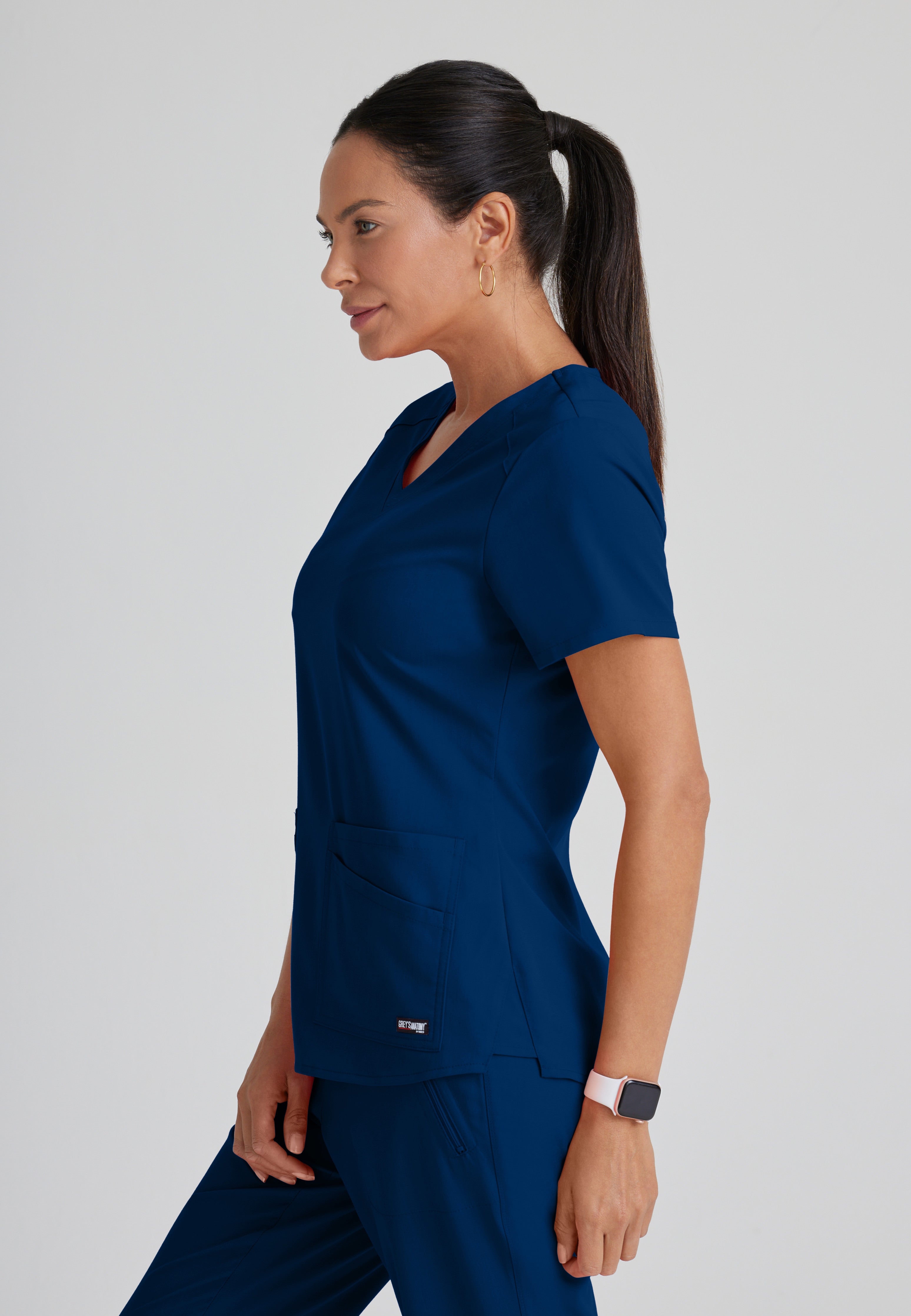 Side View of the Emma 4-Pocket V-Neck Scrub Top in Indigo from Grey's Anatomy™ by Barco Spandex Stretch