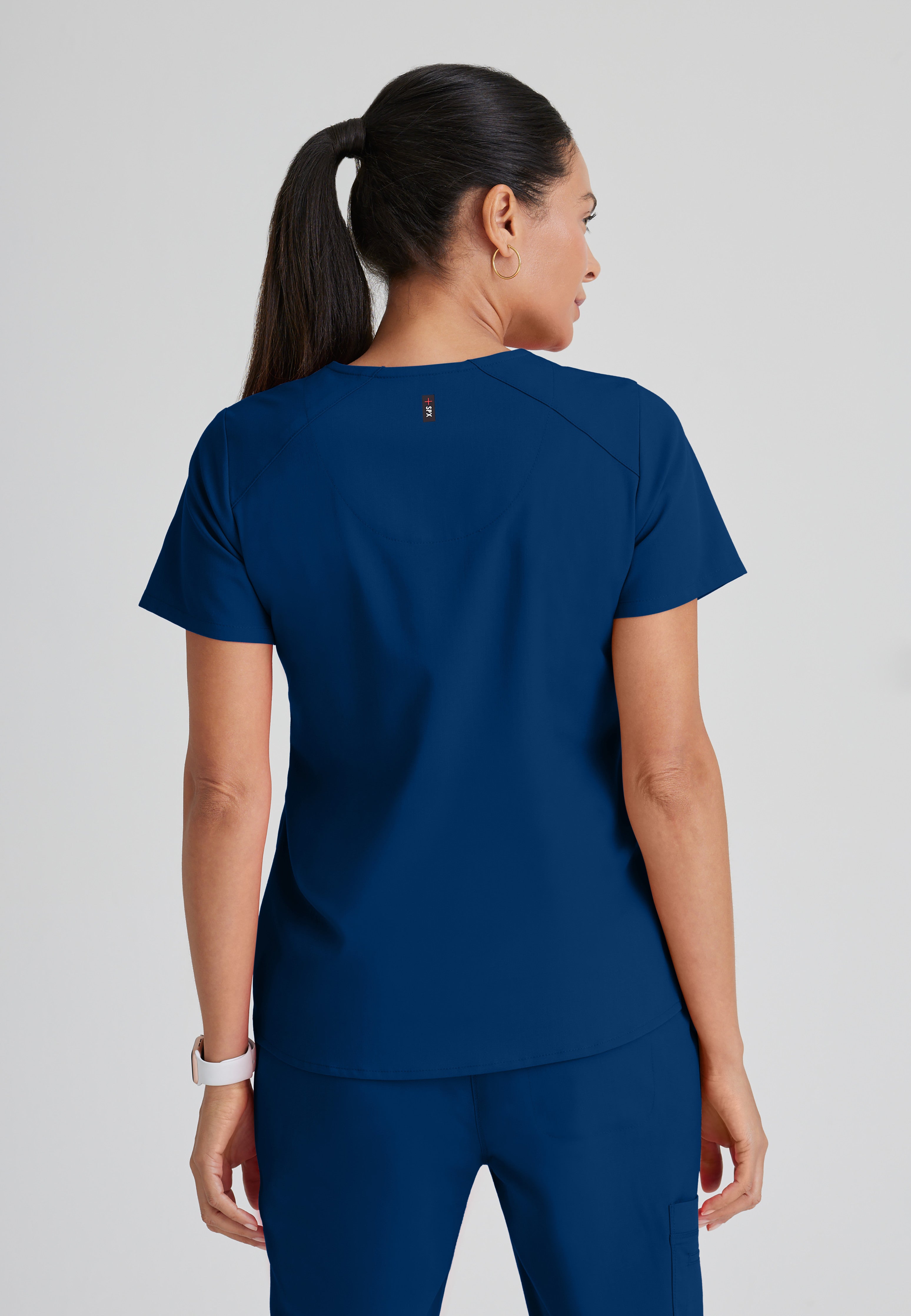 Back View of the Emma 4-Pocket V-Neck Scrub Top in Indigo from Grey's Anatomy™ by Barco Spandex Stretch