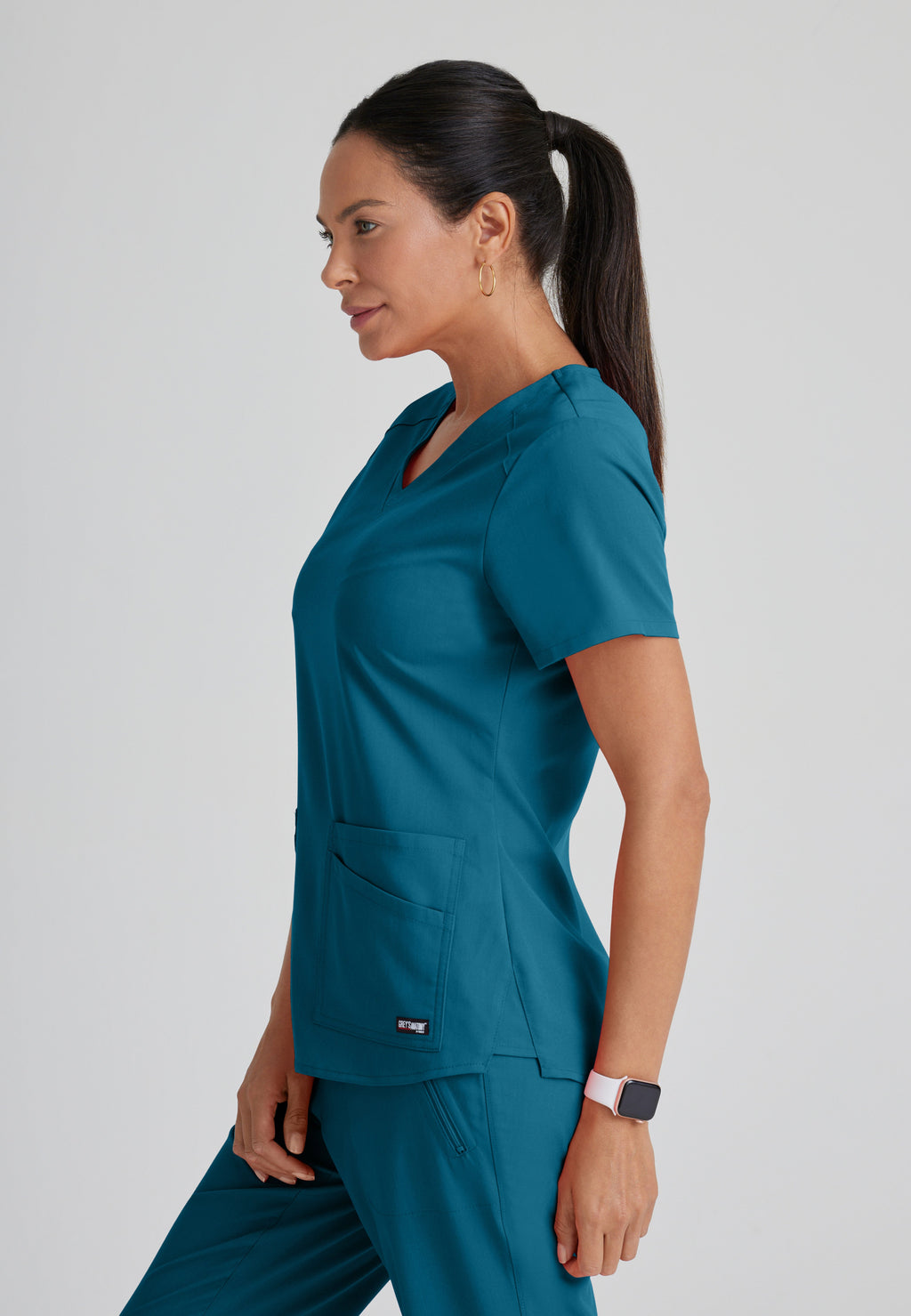Side View of the Emma 4-Pocket V-Neck Scrub Top in Bahama from Grey's Anatomy™ by Barco Spandex Stretch