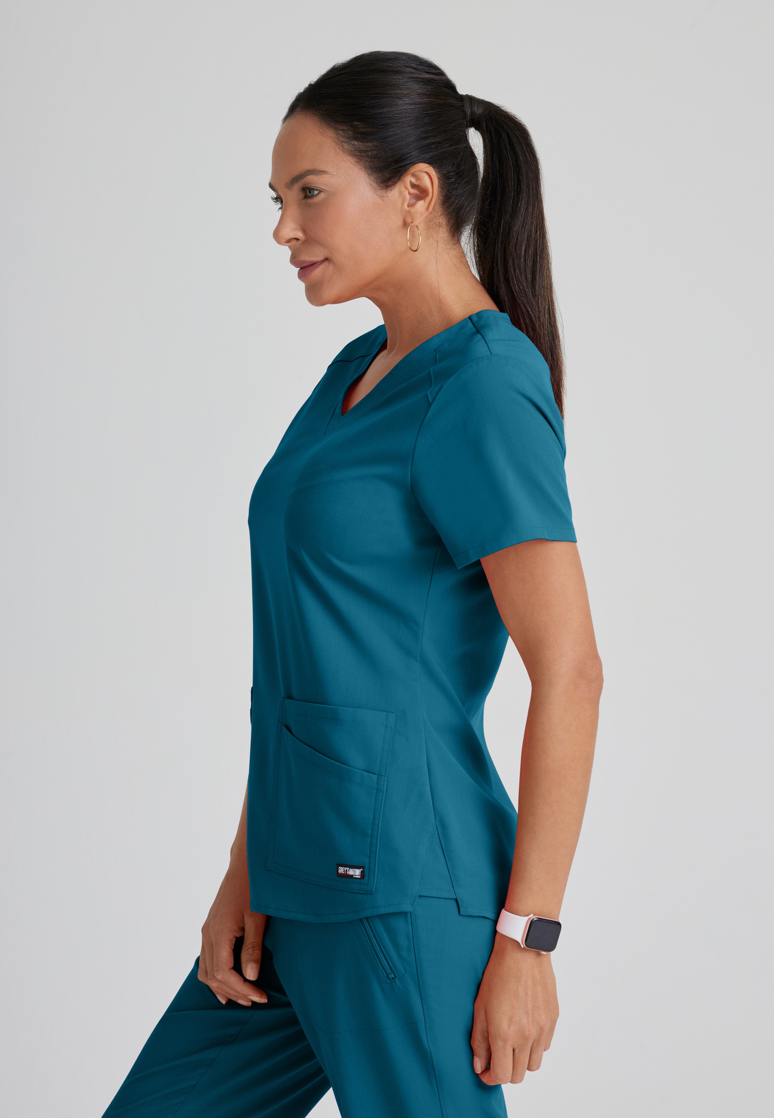 Side View of the Emma 4-Pocket V-Neck Scrub Top in Bahama from Grey's Anatomy™ by Barco Spandex Stretch