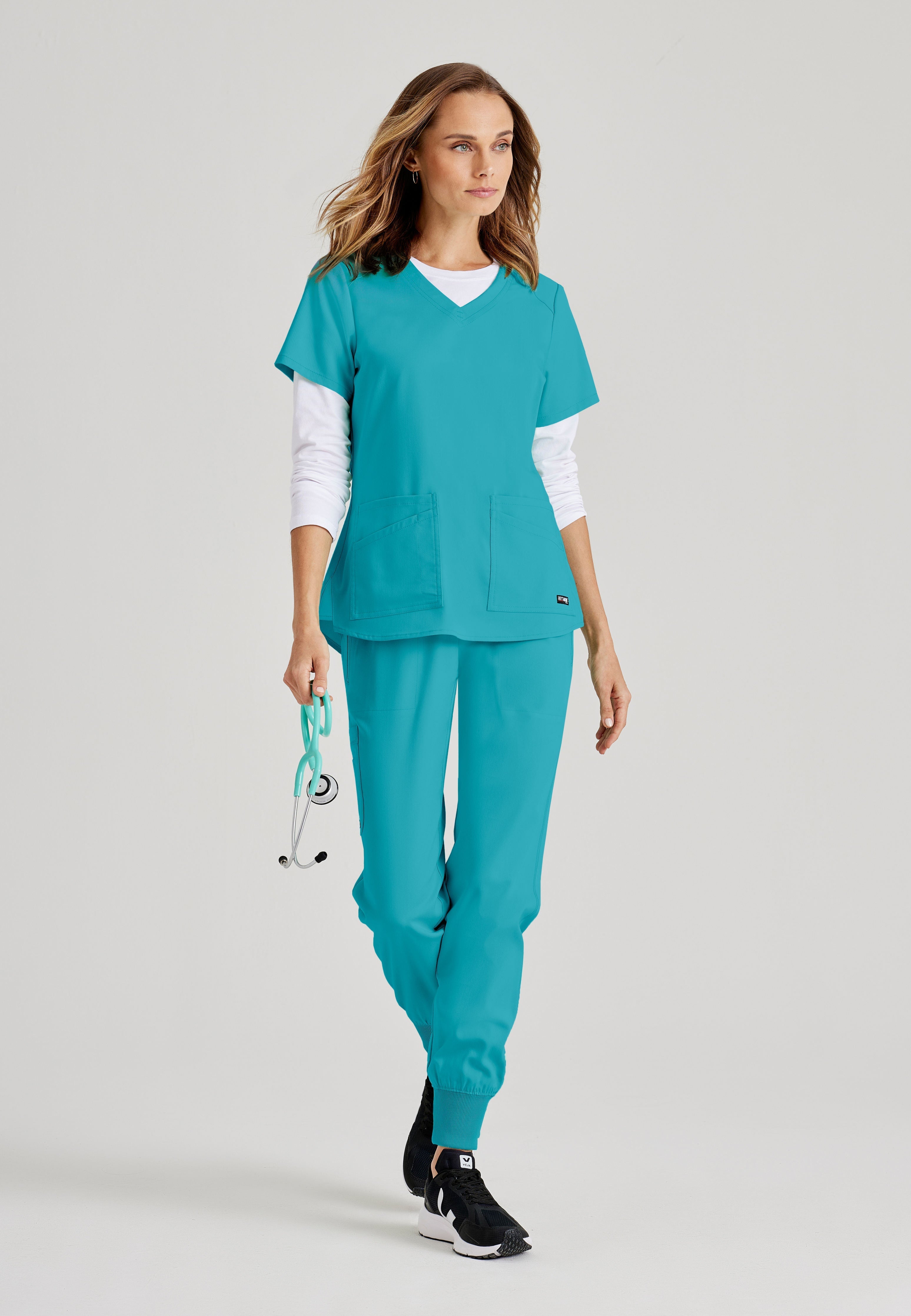 Grey's Anatomy Spandex-Stretch women's teal scrub top. V-neck. 4 pockets. Soft touch. Moisture-wicking stretch fabric.