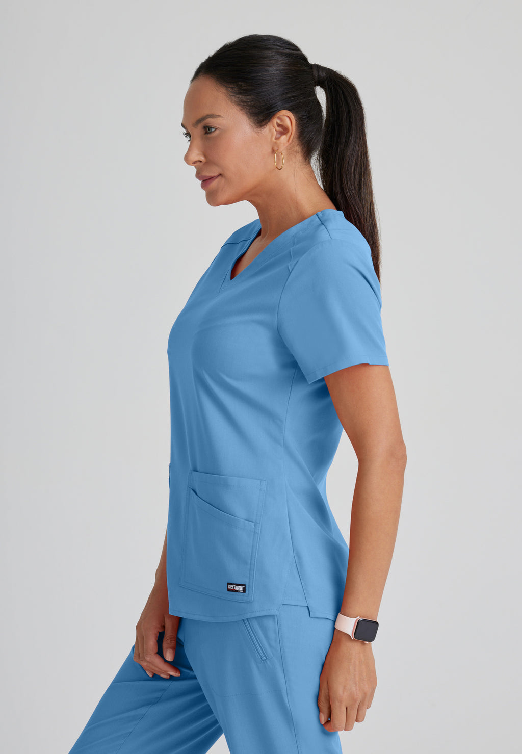 Side View of the Emma 4-Pocket V-Neck Scrub Top in Ciel Blue from Grey's Anatomy™ by Barco Spandex Stretch