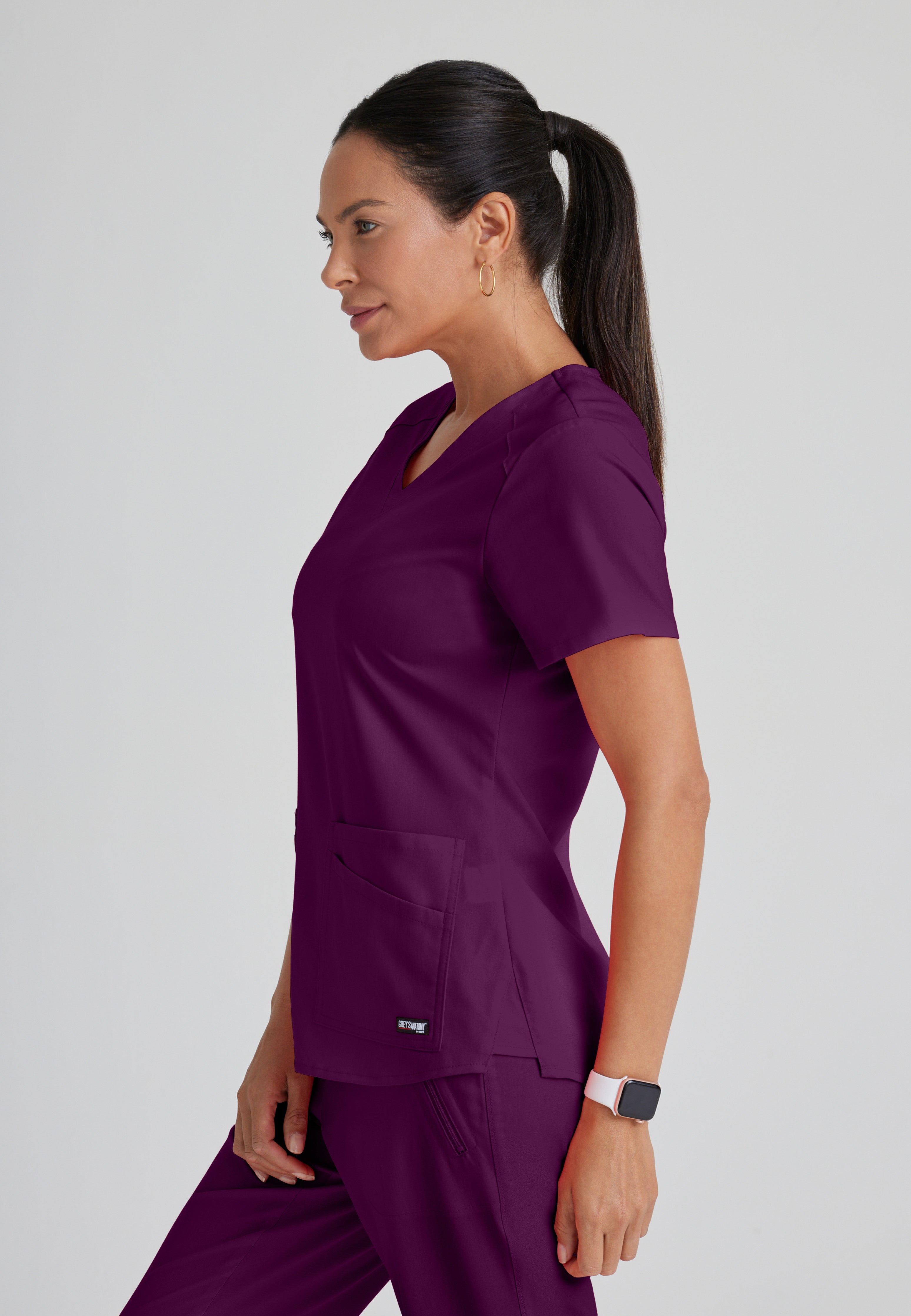 Side View of the Emma 4-Pocket V-Neck Scrub Top in Wine from Grey's Anatomy™ by Barco Spandex Stretch