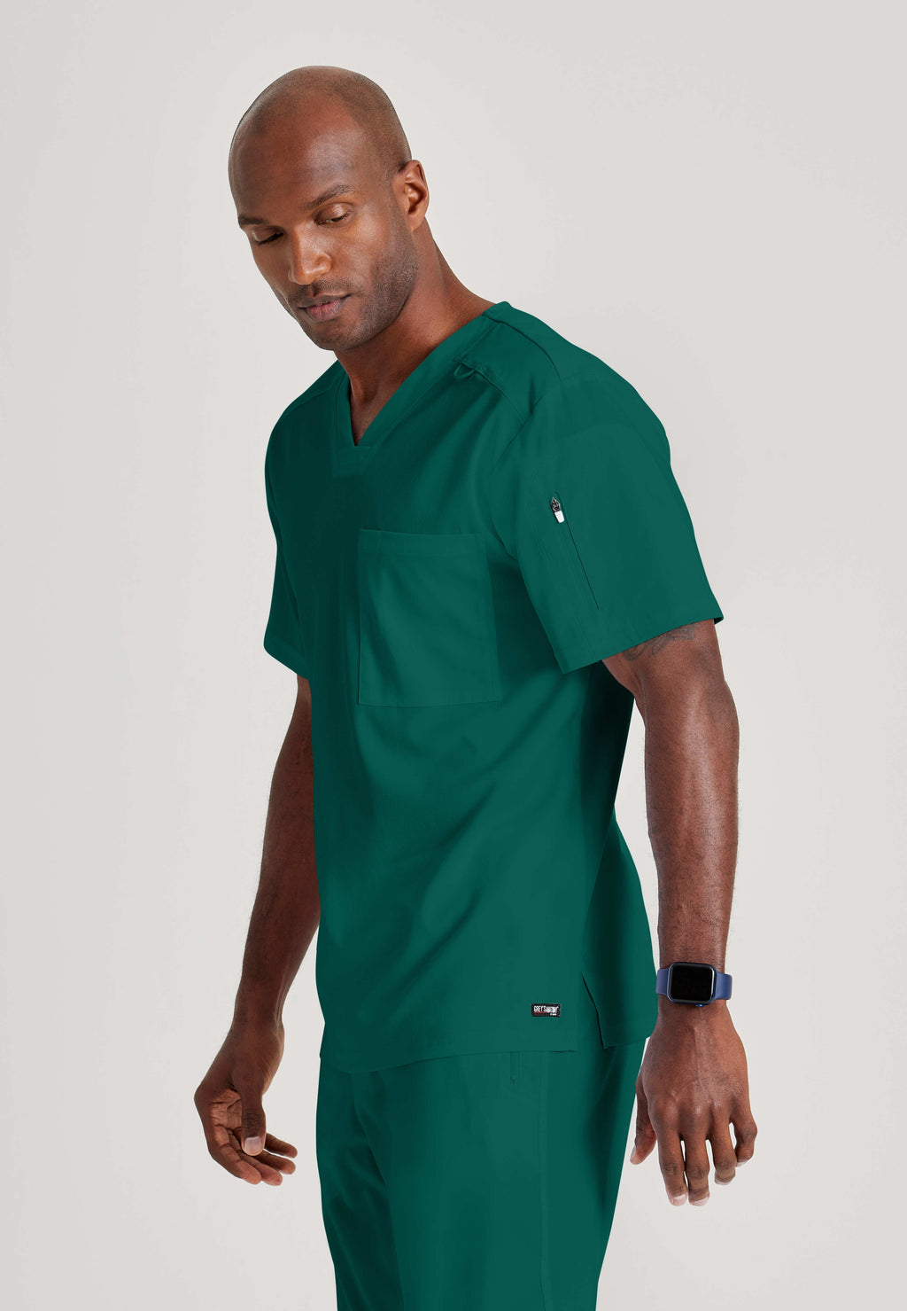 Grey's Anatomy Spandex-Stretch Men’s hunter green Chest Pocket V-Neck Scrub Top. Bungee loop. Soft stretch fabric wicks moisture. 