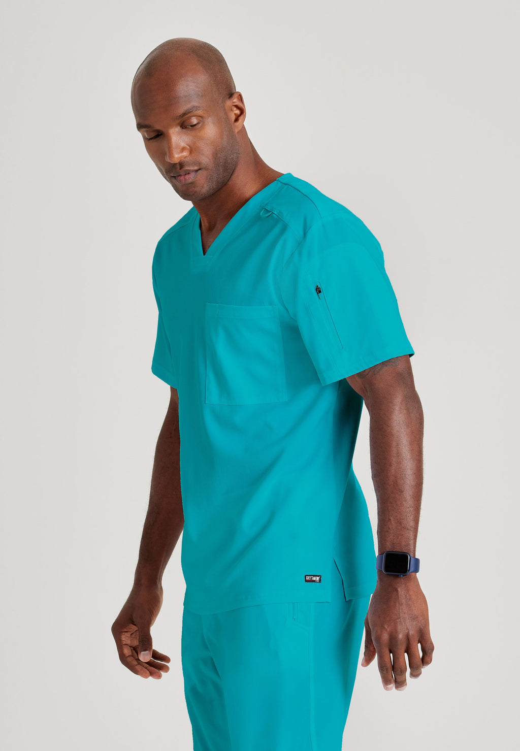 Grey's Anatomy Spandex-Stretch Men’s teal Chest Pocket V-Neck Scrub Top. Bungee loop. Soft stretch fabric wicks moisture. 