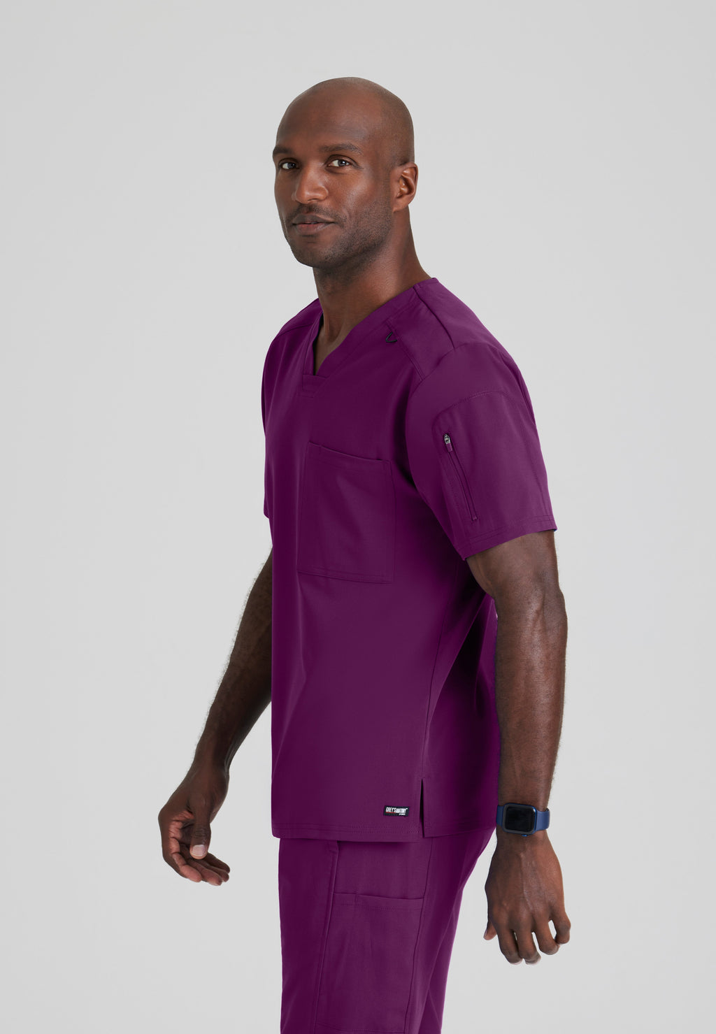 Side View of the Murphy 2-Pocket V-Neck Scrub Top in Wine from Grey's Anatomy™ by Barco Spandex Stretch