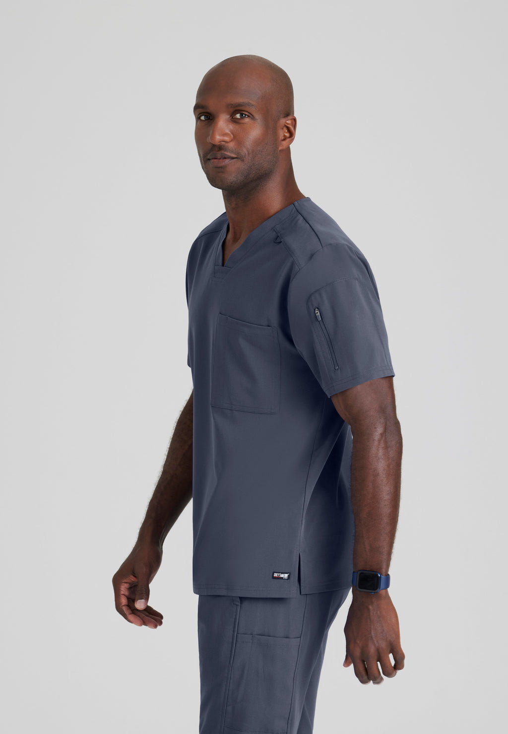 Side View of the Murphy 2-Pocket V-Neck Scrub Top in Steel from Grey's Anatomy™ by Barco Spandex Stretch