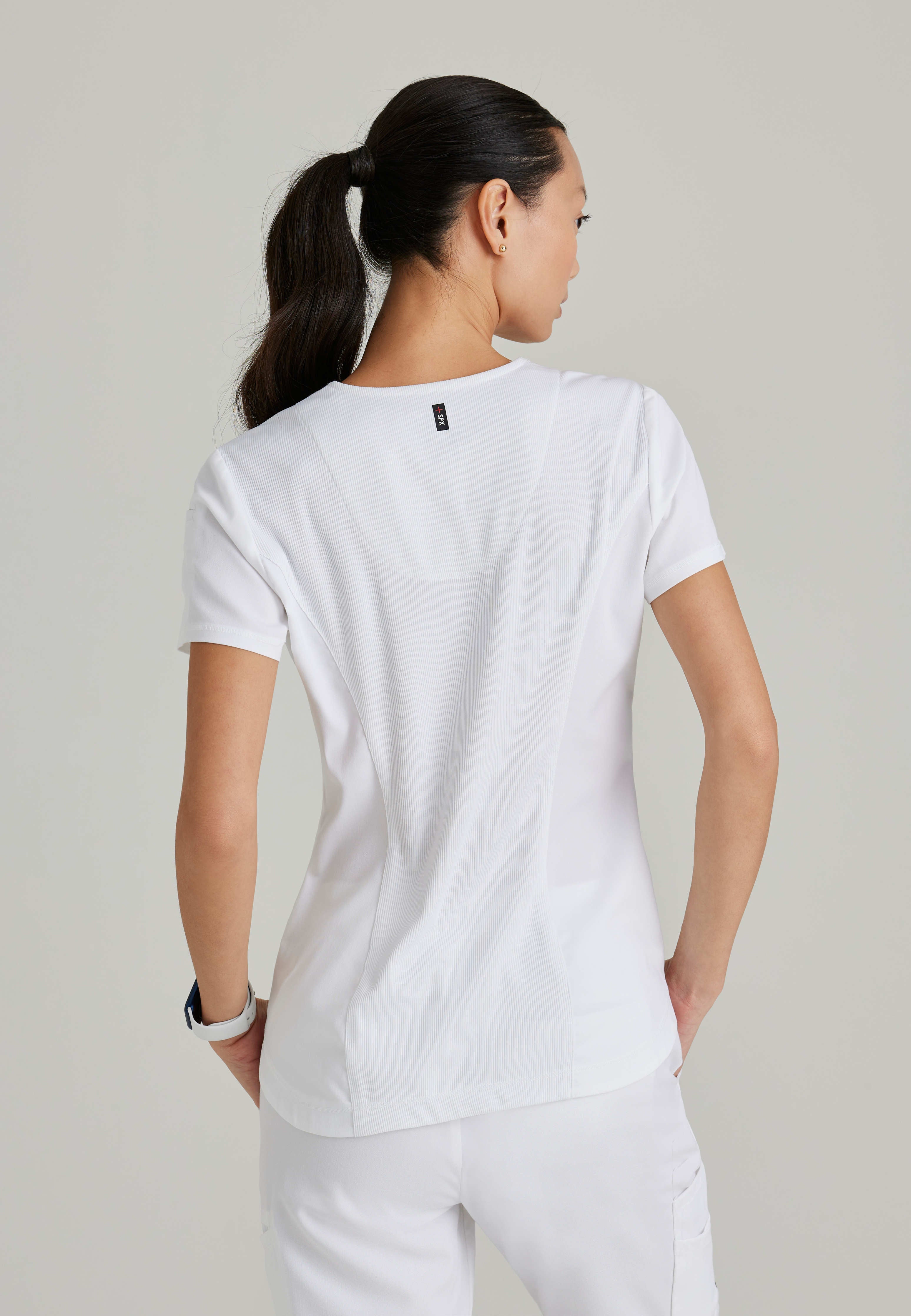 Side View of the Capri 2-Pocket Hourglass V-Neck Scrub Top in White from Grey's Anatomy™ by Barco Spandex Stretch