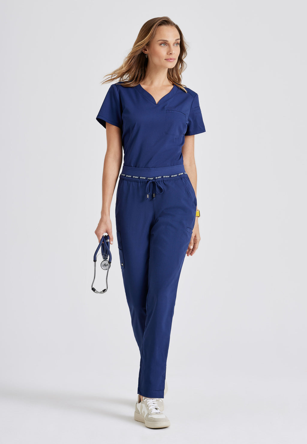 Full Body View of the Capri 2-Pocket Hourglass V-Neck Scrub Top in Indigo from Grey's Anatomy™ by Barco Spandex Stretch
