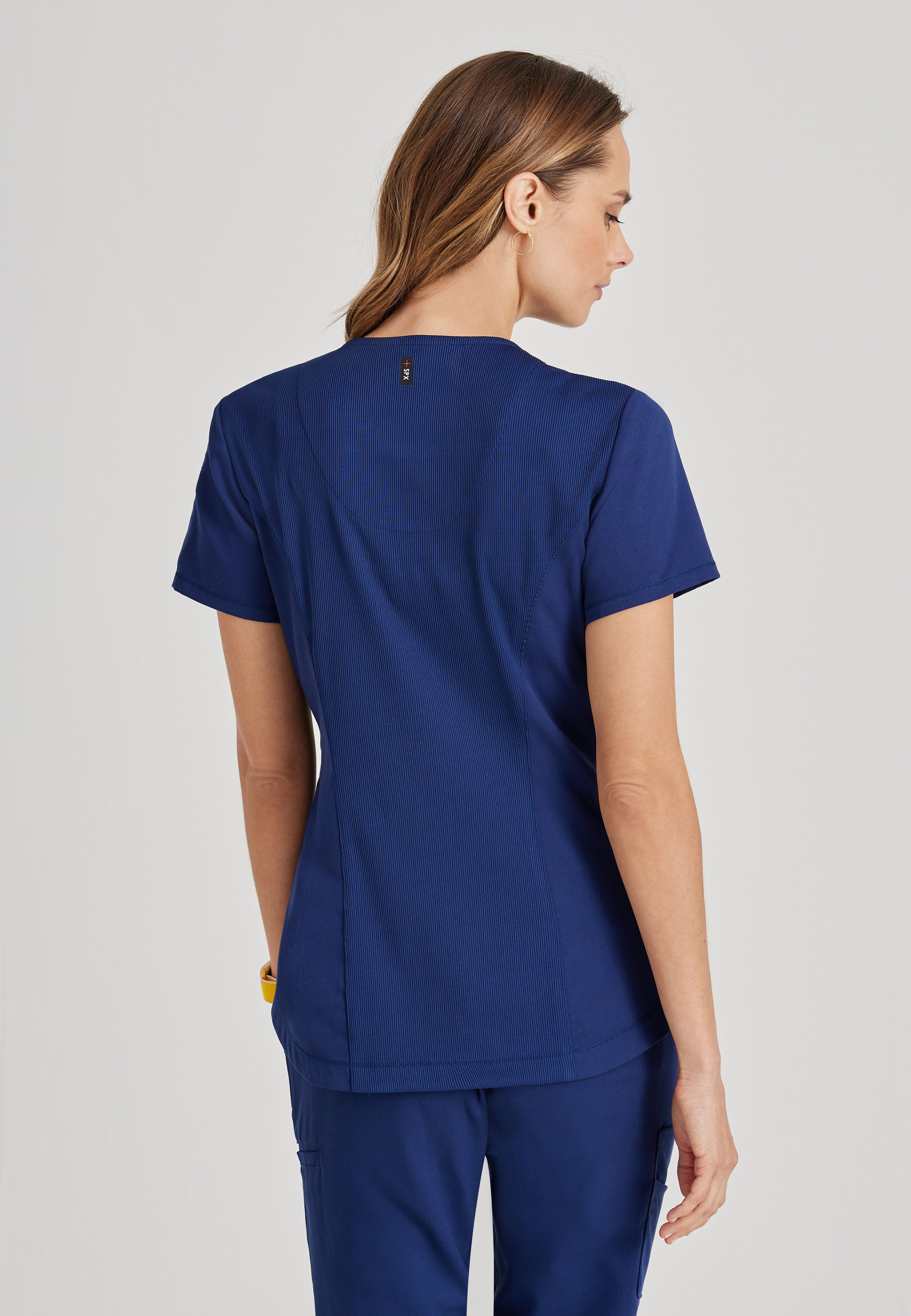 Back View of the Capri 2-Pocket Hourglass V-Neck Scrub Top in Indigo from Grey's Anatomy™ by Barco Spandex Stretch