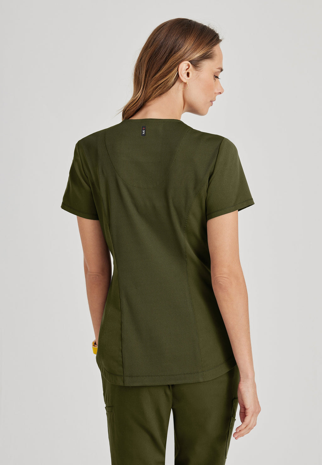 Back View of the Capri Tuck-in Scrub Top in Olive from Grey's Anatomy™ by Barco Spandex Stretch