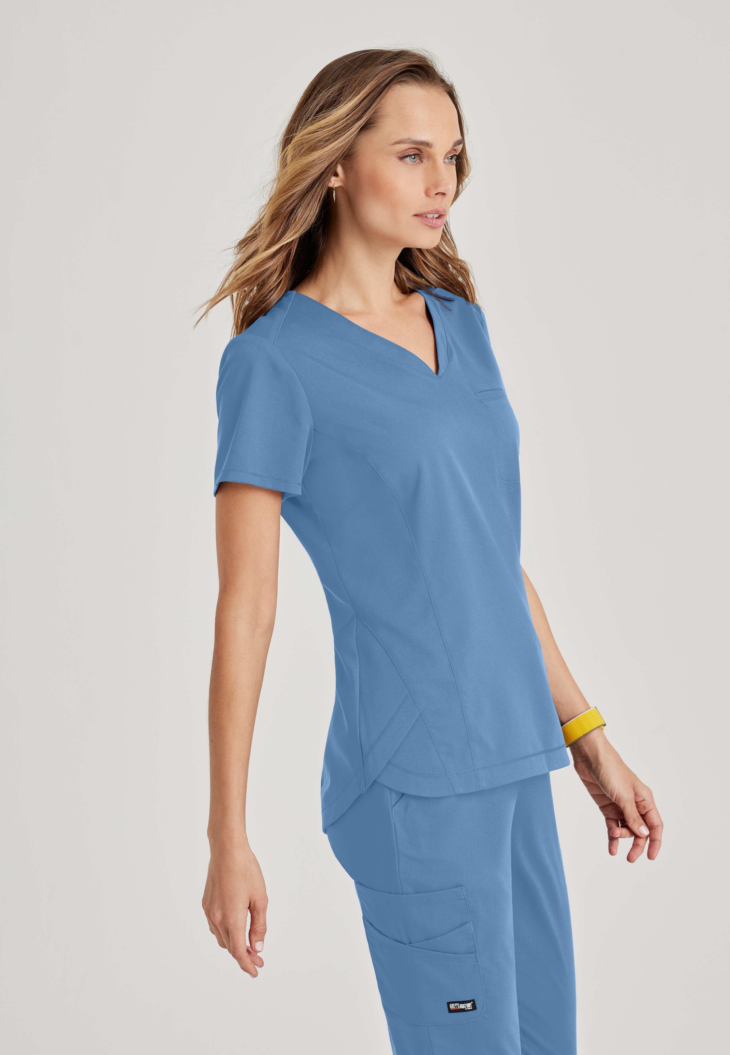 Full Body View of the Capri 2-Pocket Hourglass V-Neck Scrub Top in Ciel Blue from Grey's Anatomy™ by Barco Spandex Stretch